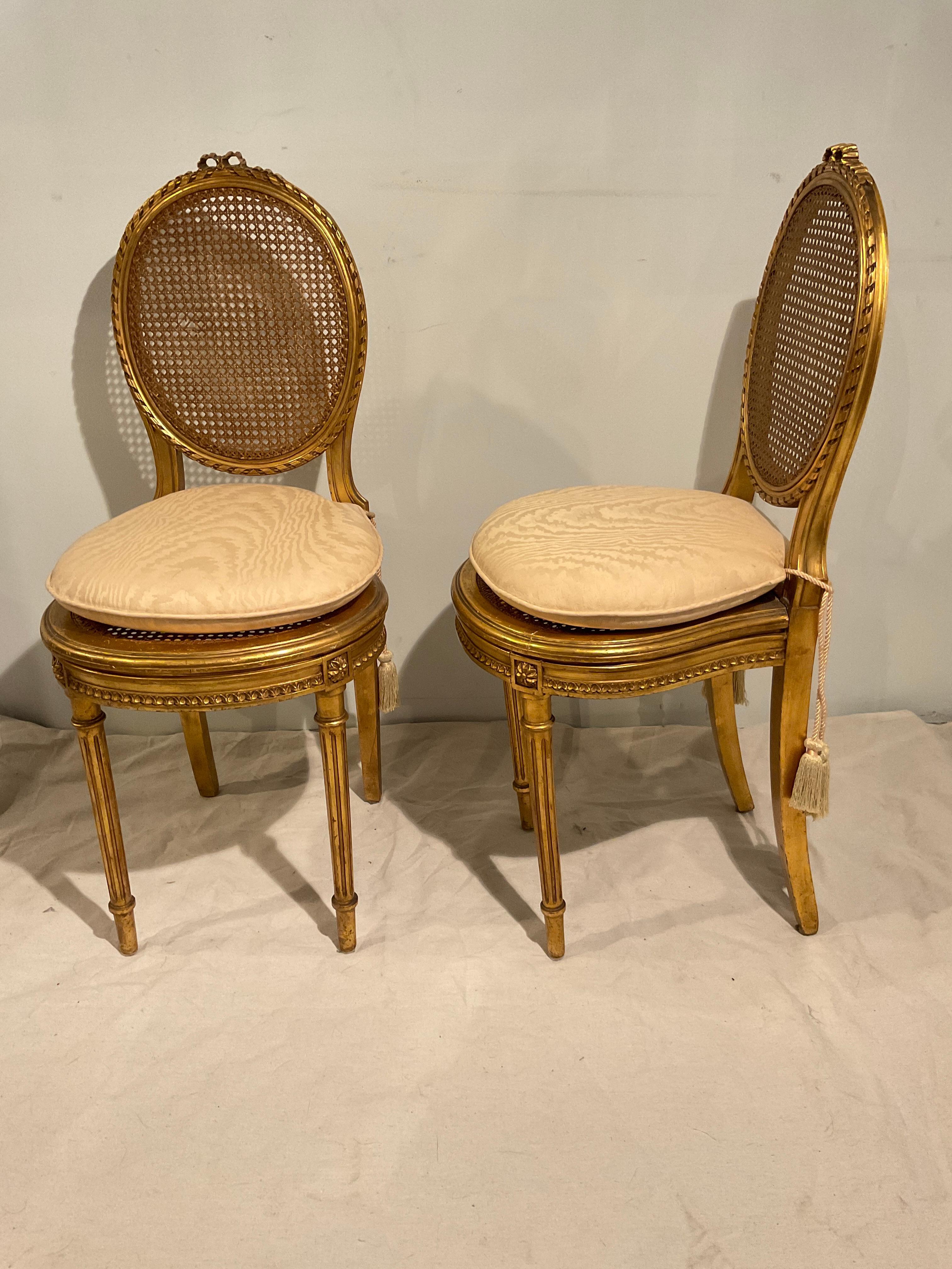 Pair of 1920s French gilt carved wood Louis XVI petite chairs .Hole in caning on back of one chair.