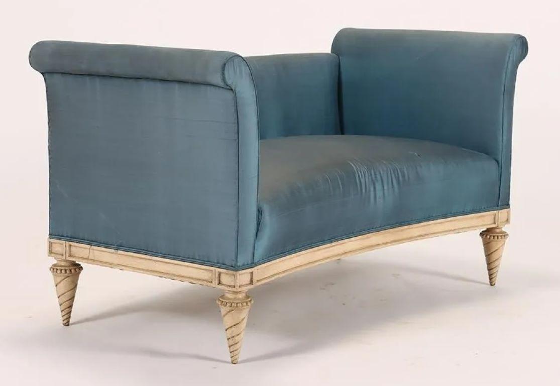 A pair of 1920s French Louis XVI style high back settees/loveseats in the manner of Jansen. Featuring carved twisted tapered legs and rolled upholstered arms, blue silk upholstery in distressed condition and should be replaced. A great opportunity