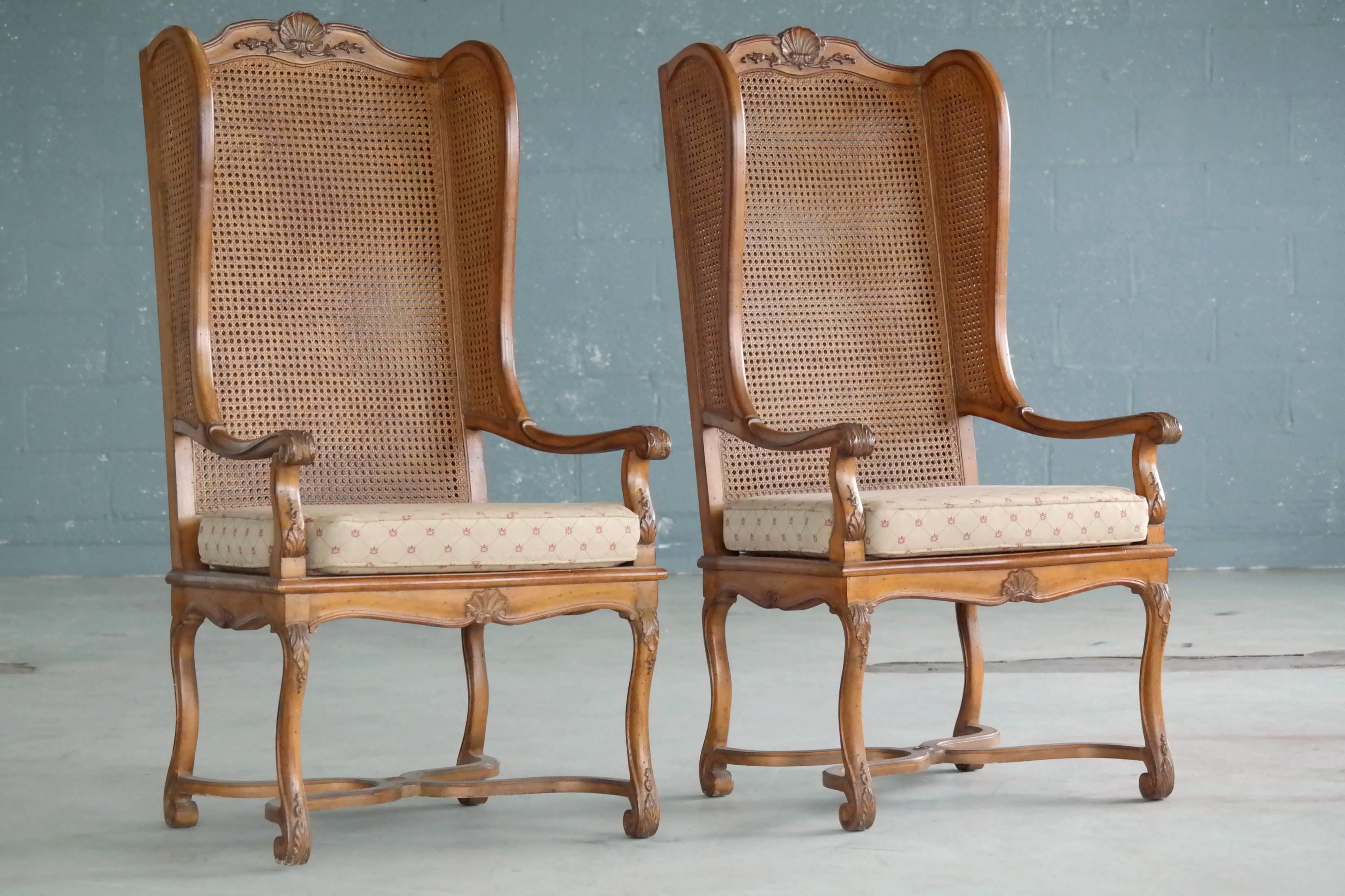 Super stylish pair of 1920s American Hollywood Regency tall wingback chairs in rare double cane. The chairs show appropriate age wear in the form of minor nicks and scuffs while the cane is in very near perfect condition. The chairs were part of the