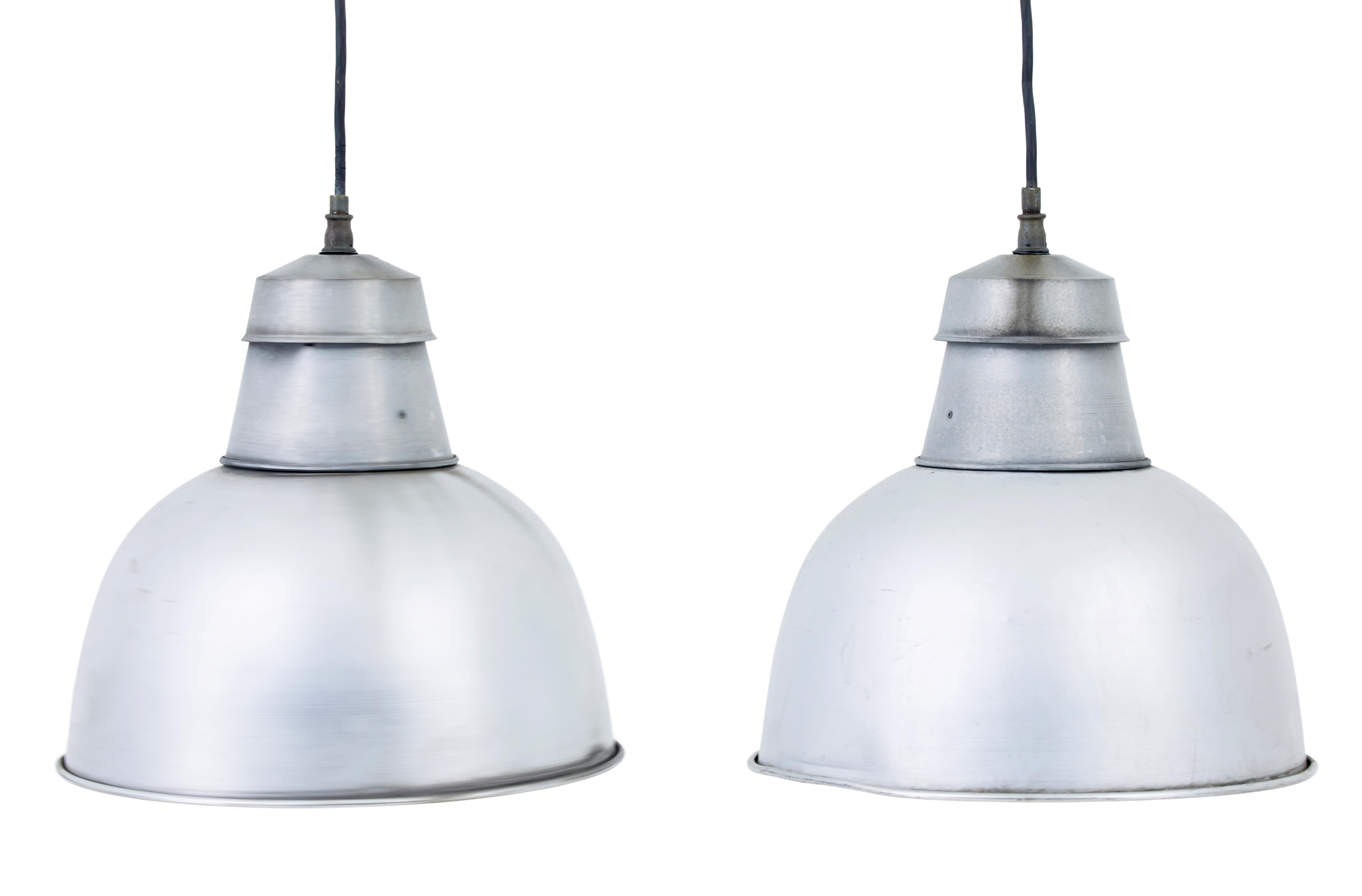 Pair of 1920’s industrial metal hanging ceiling lights.

Ideal for an installation into the modern home for hanging over the dining table or hallway.

Expected marks, staining and minor dents from use which only adds to the look.

These lamps are