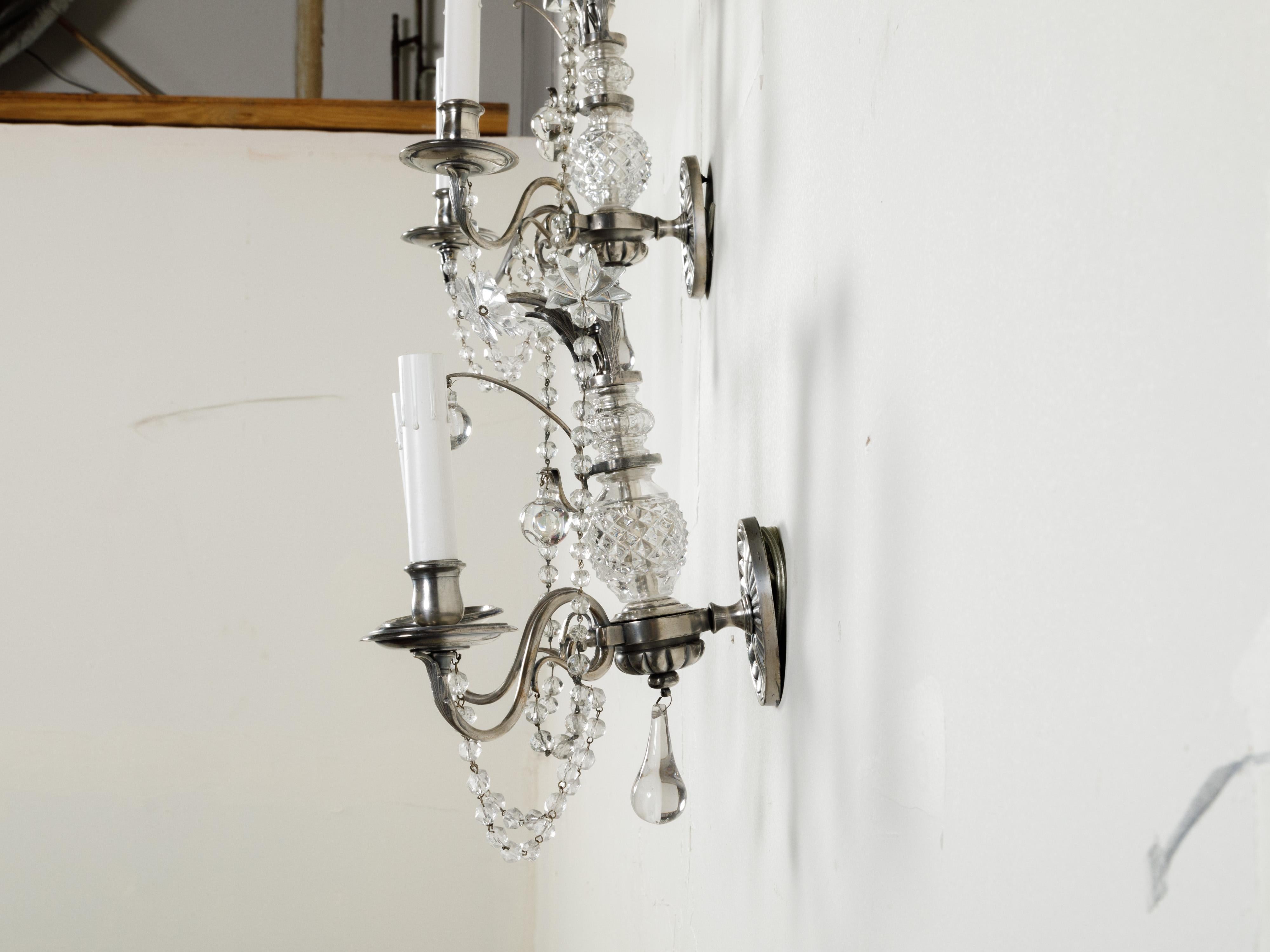 20th Century Pair of 1920s Metal and Crystal Two-Arm Wall Sconces with Beads and Rosettes For Sale