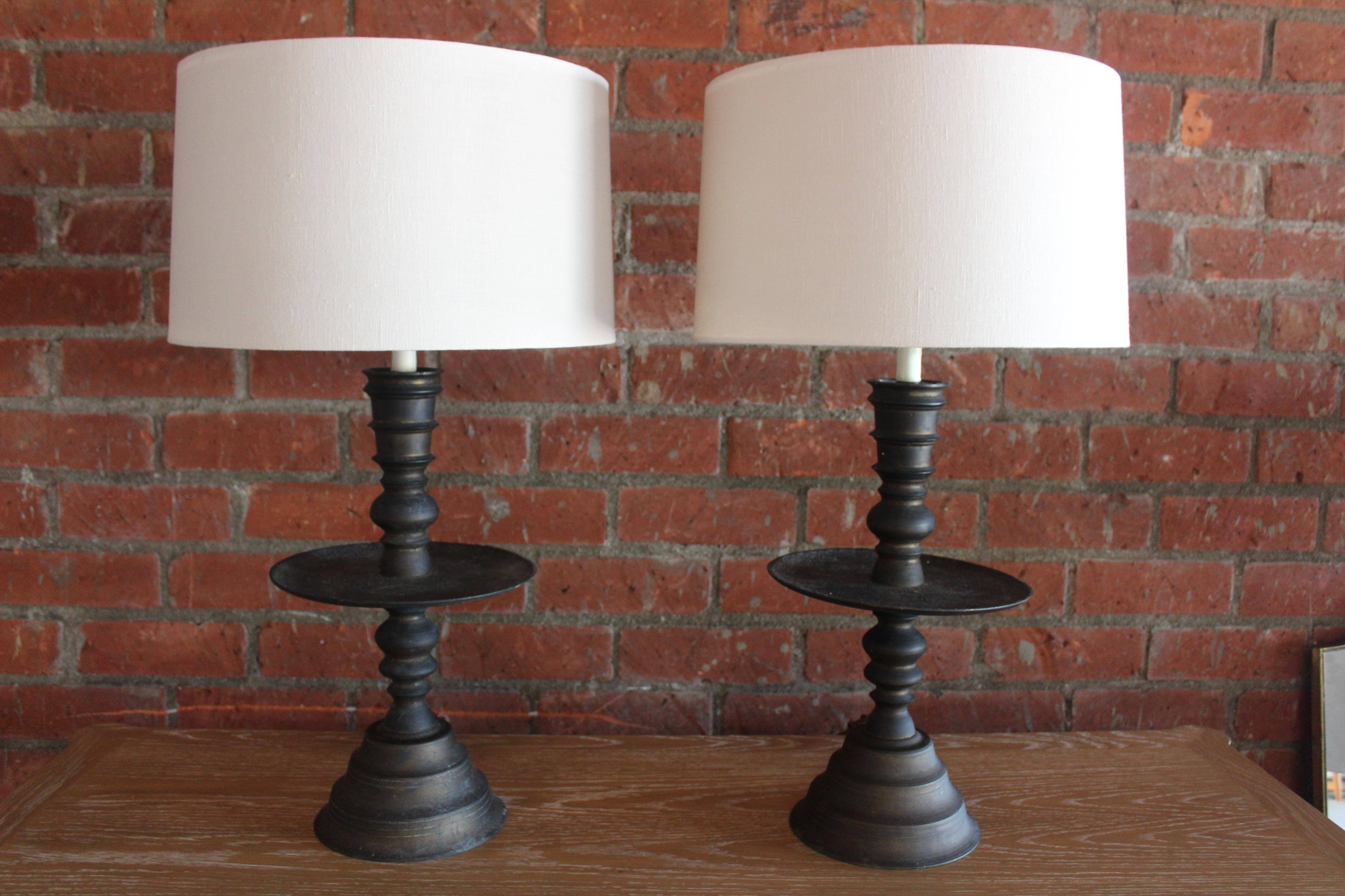 Pair of vintage 1920s solid brass candlestick table lamps from Turkey. Newly rewired and fitted with custom made shades in Belgian linen. The brass shows a wonderful heavy patina. They are 30.5