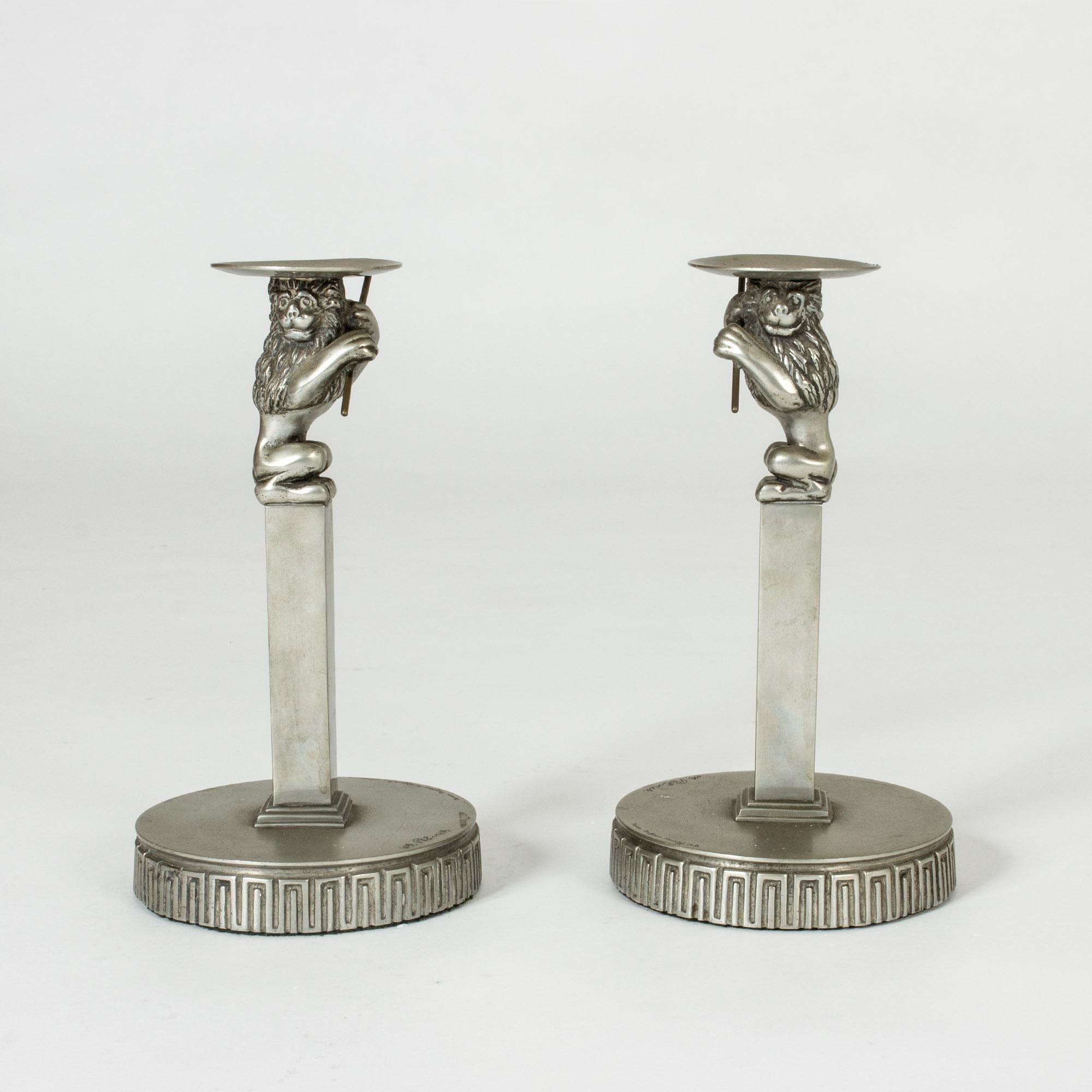 Pair of stunning pewter candlesticks by Anna Petrus, designed in the period 1925-1927. The candleholders sit on the heads of Petrus’ signature lions with expressive faces and flutes in their paws. The wide bases are decorated with a classic meander
