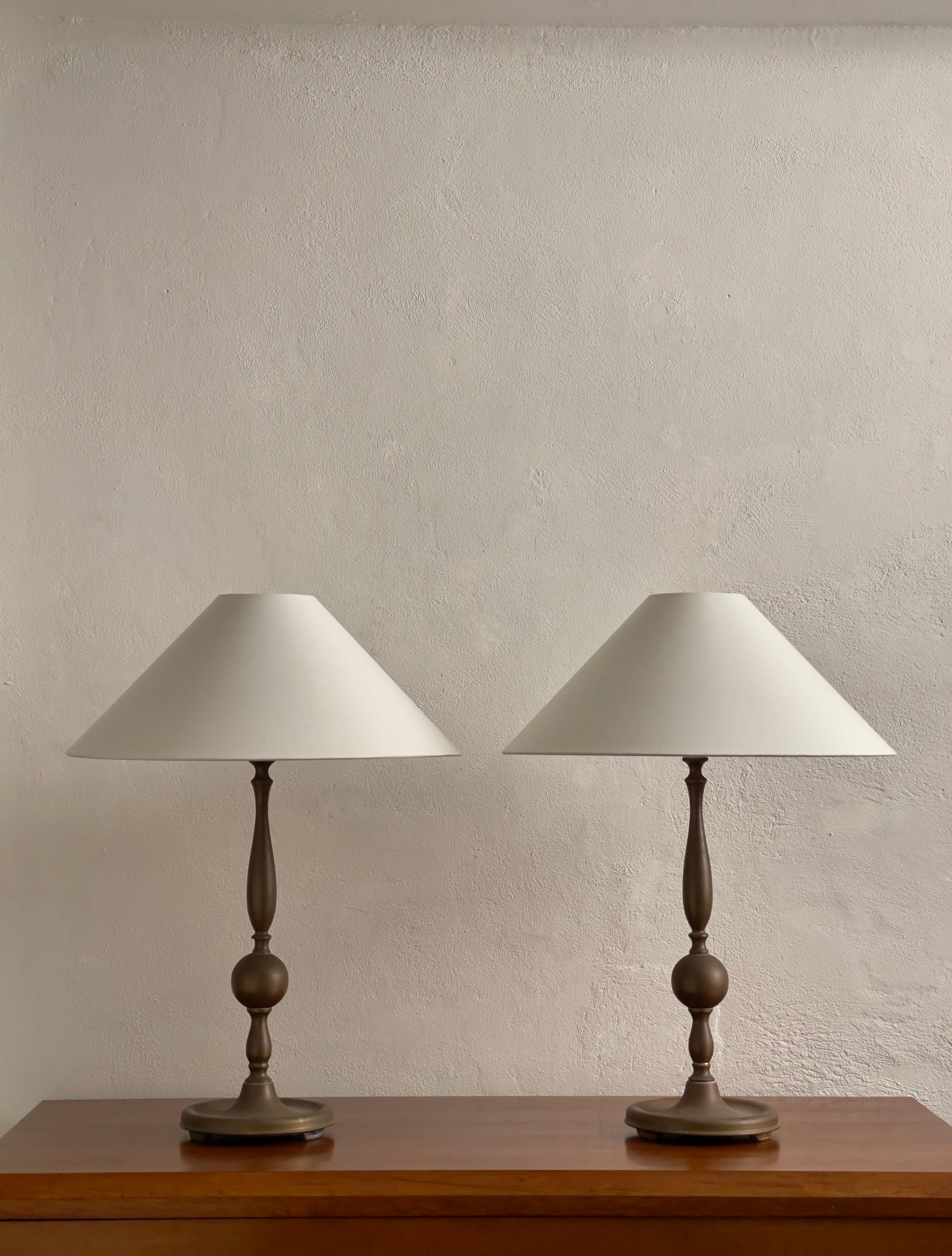 Rare pair of early 20th century Scandinavian table lamps in beautifully patinated brass. Very strong sculptural design featuring an elegant and unique handmade construction. 

Including new off white fabric wire. These lamps can be wired with plugs