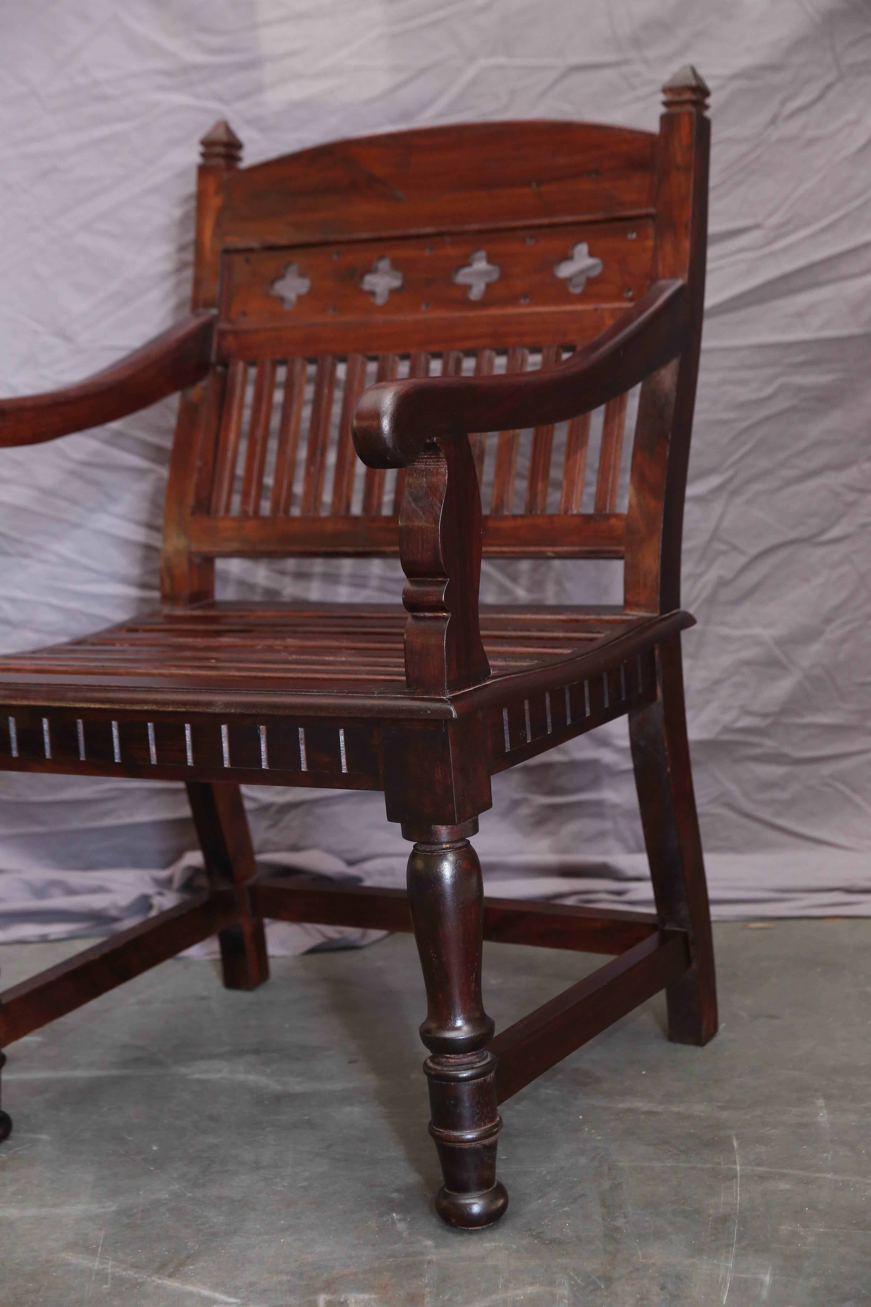 These two teak wood chairs designed for comfort come from a west coast monastery. These sofa like chairs were used in the large waiting rooms for dignitaries who come to visit the bishop. The rich wood patina combined with old world carpentry will