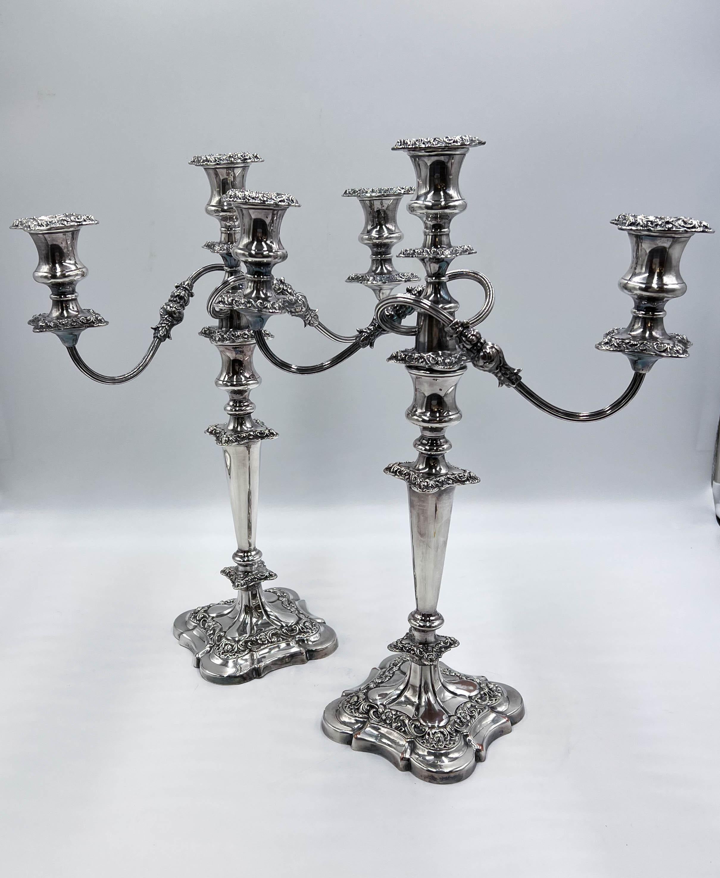 A pair of antique silver-plated candelabras/candlesticks crafted by the renowned English company William Suckling Ltd, dating back to the 1920s. For versatility, the arm of the candelabra is removable, transforming the candelabra into a standalone
