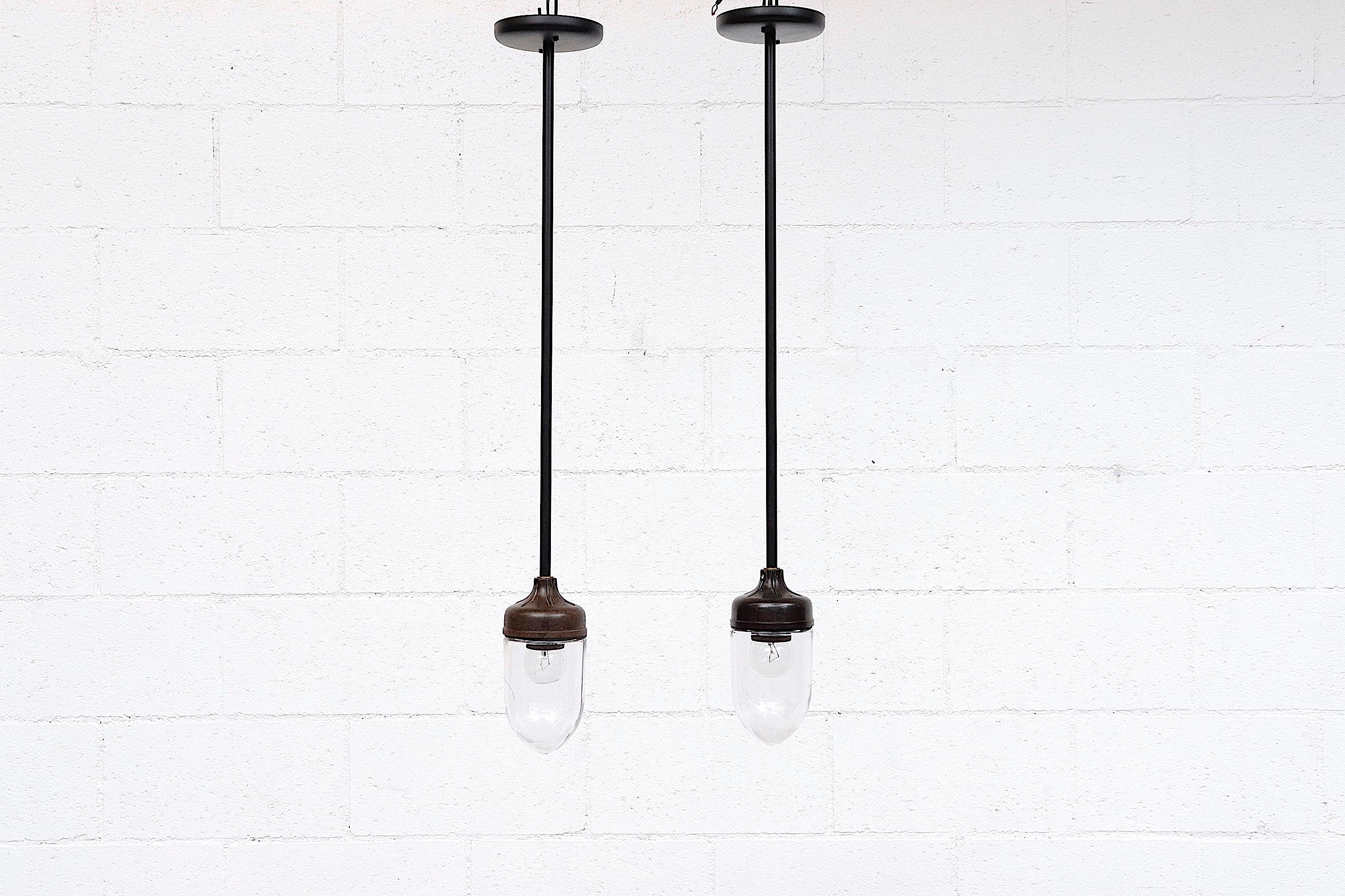 Pair of 1930s-1940s Bakelite Factory lights with original bottle glass shades and new powder coated rods.