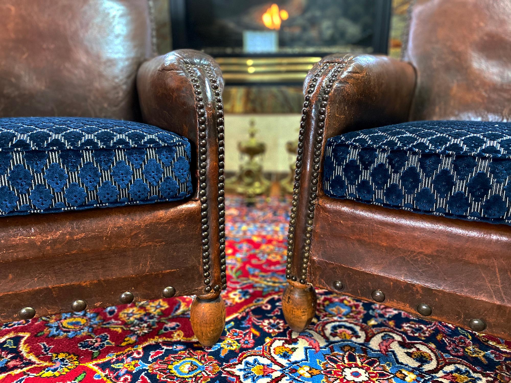 Pair of 1930 Art Deco leather chairs are from Paris, France, circa 1930. Cushions reupholstered with Christian LaCroix blue velvet fabric.
The chair features their original leather with a distressed and aged patina in very good condition. 
Stylish
