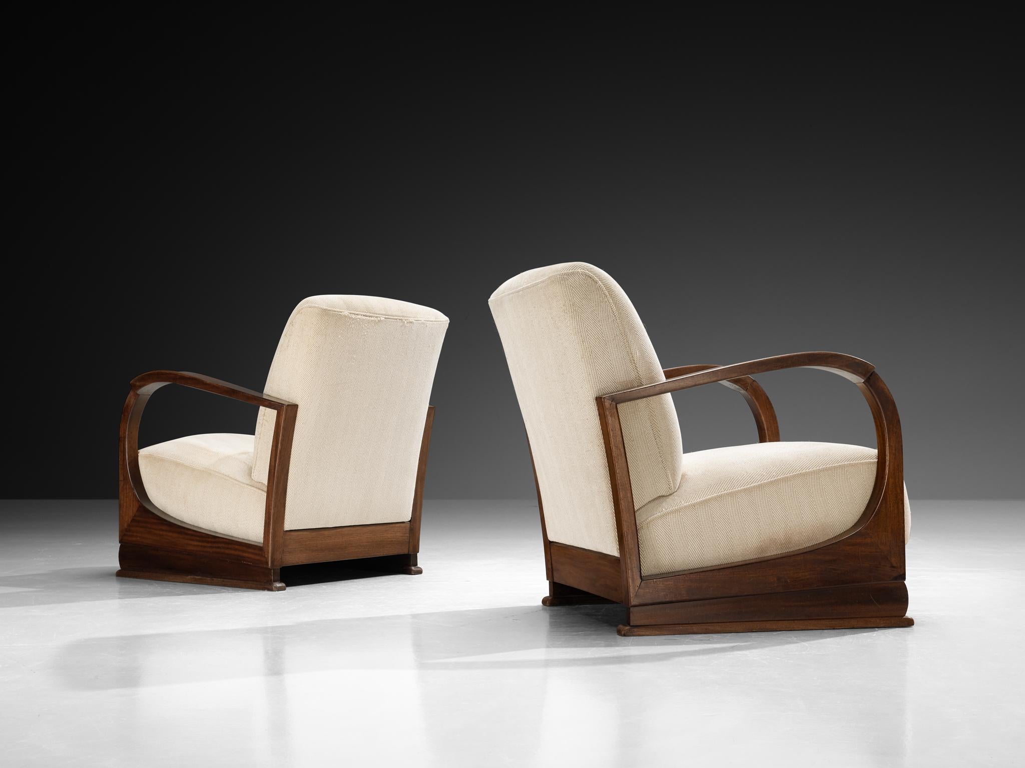 Coppia di poltrone, mogano, tessuto, Europa, anni '30 

Queste poltrone Art Deco degli anni '30 presentano un profilo basso con una base rettangolare che fonda saldamente il pezzo e ampi cuscini squadrati che definiscono la seduta e lo schienale. Si