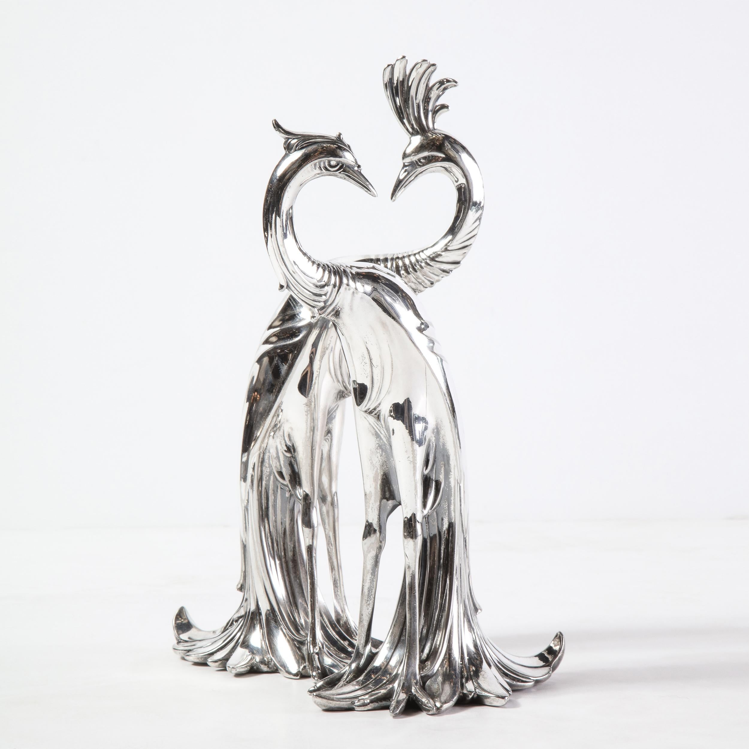This stunning pair of Art Deco silverplated peacock sculptures were realized in the United States circa 1930. They represent a pair of peacocks- one male and one female- rendered in a highly stylized and quintessentially Art Deco style. With their