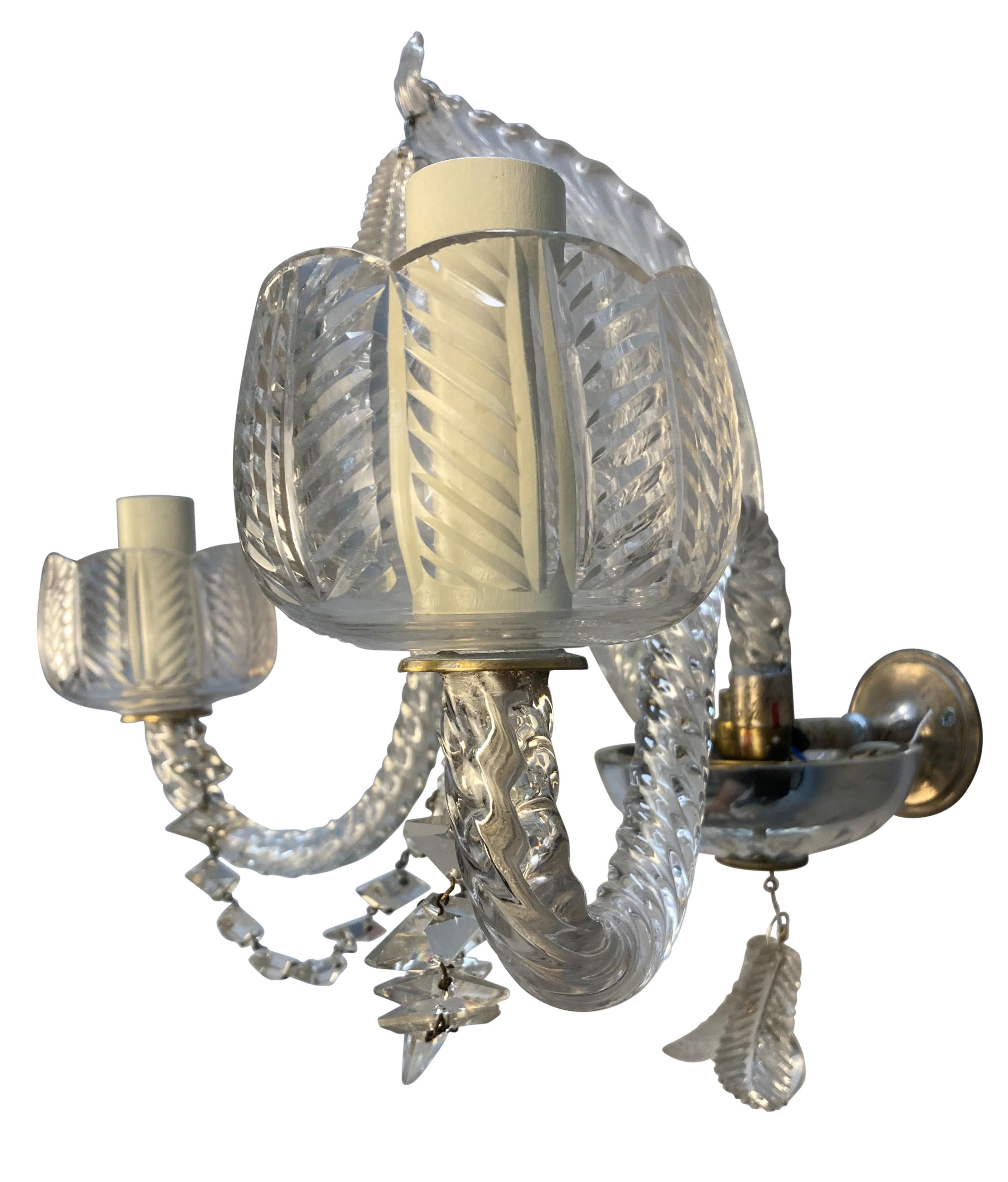 A pair of good quality French Baccarat cut glass, twin branch wall lights, with foliate patterns throughout. With a cut glass leaf at the centre of each, leaf pendants, diamond cut chains and leaf pattern sconce holders.