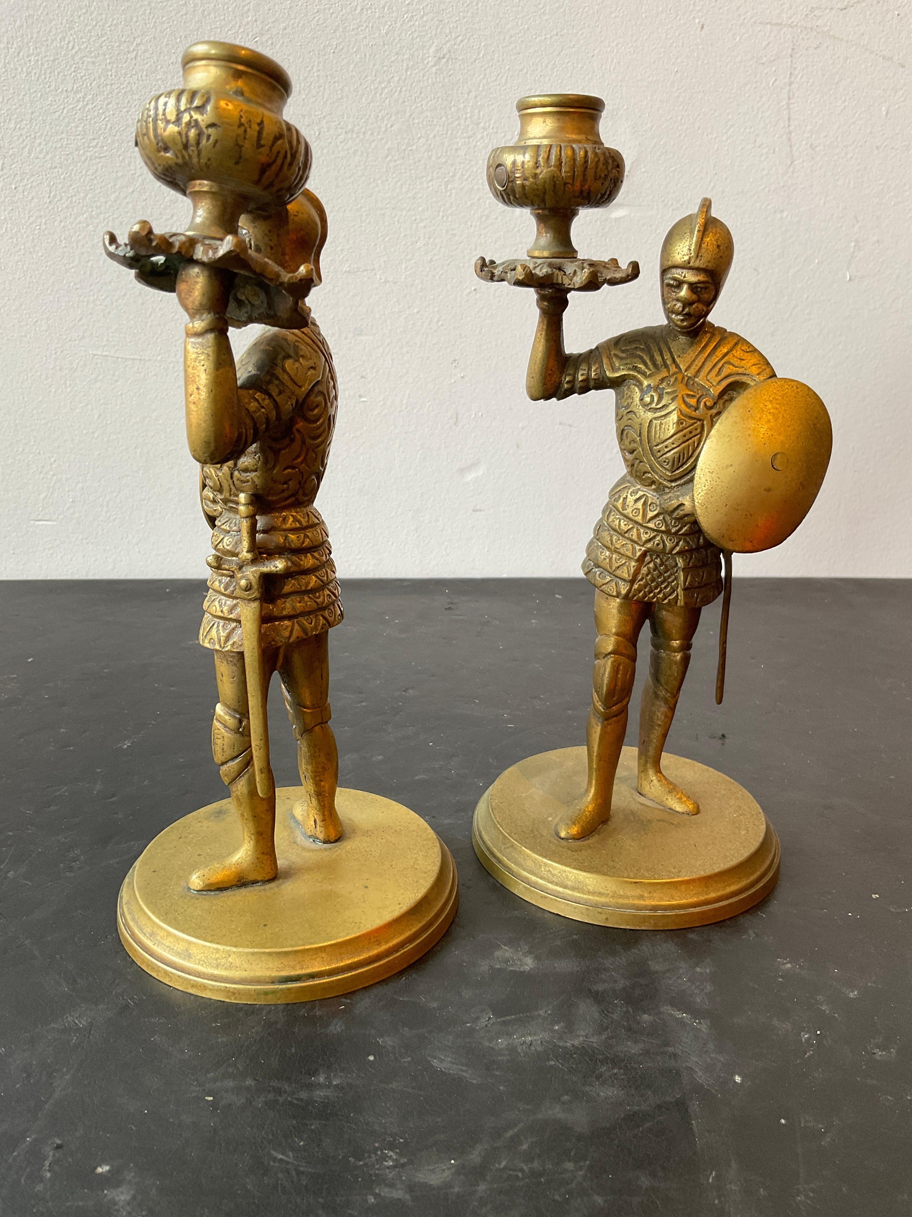 Pair of 1930s bronze knight candlesticks. One arm is bent as shown in picture.