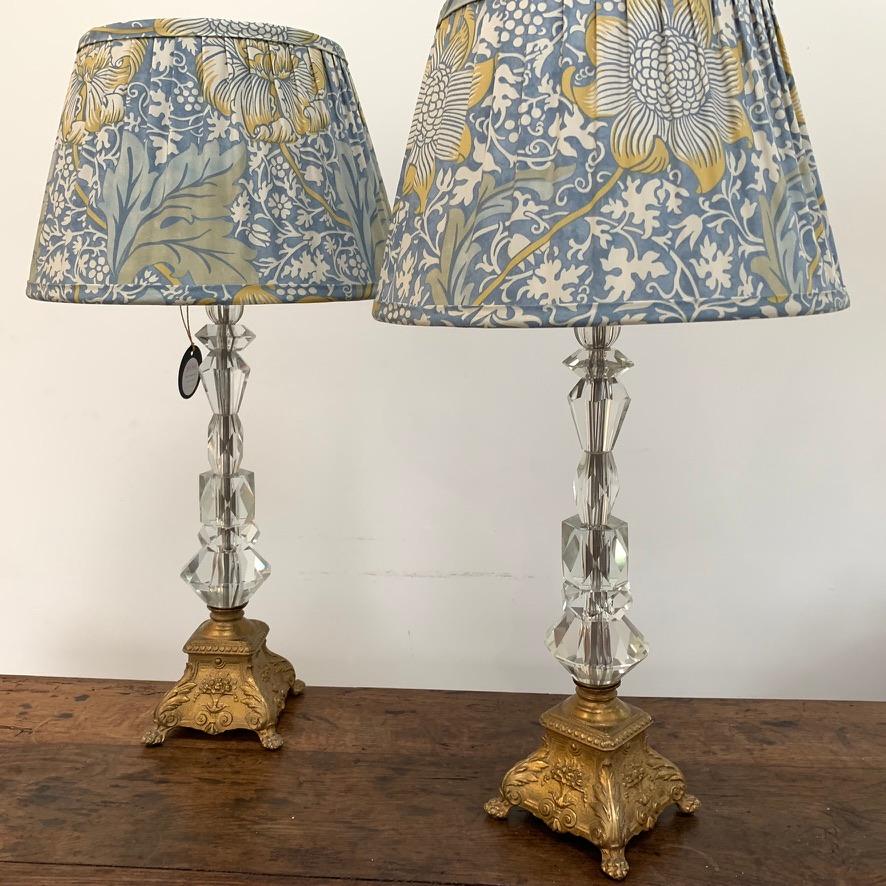 Beautiful pair of crystal lamps with brass bases in a French Louis xv style, fitted with a pair of handmade French drum shades using William Morris fabric (by thatrebelhouse).
I have priced the lamps to include this pair of handmade shades as I