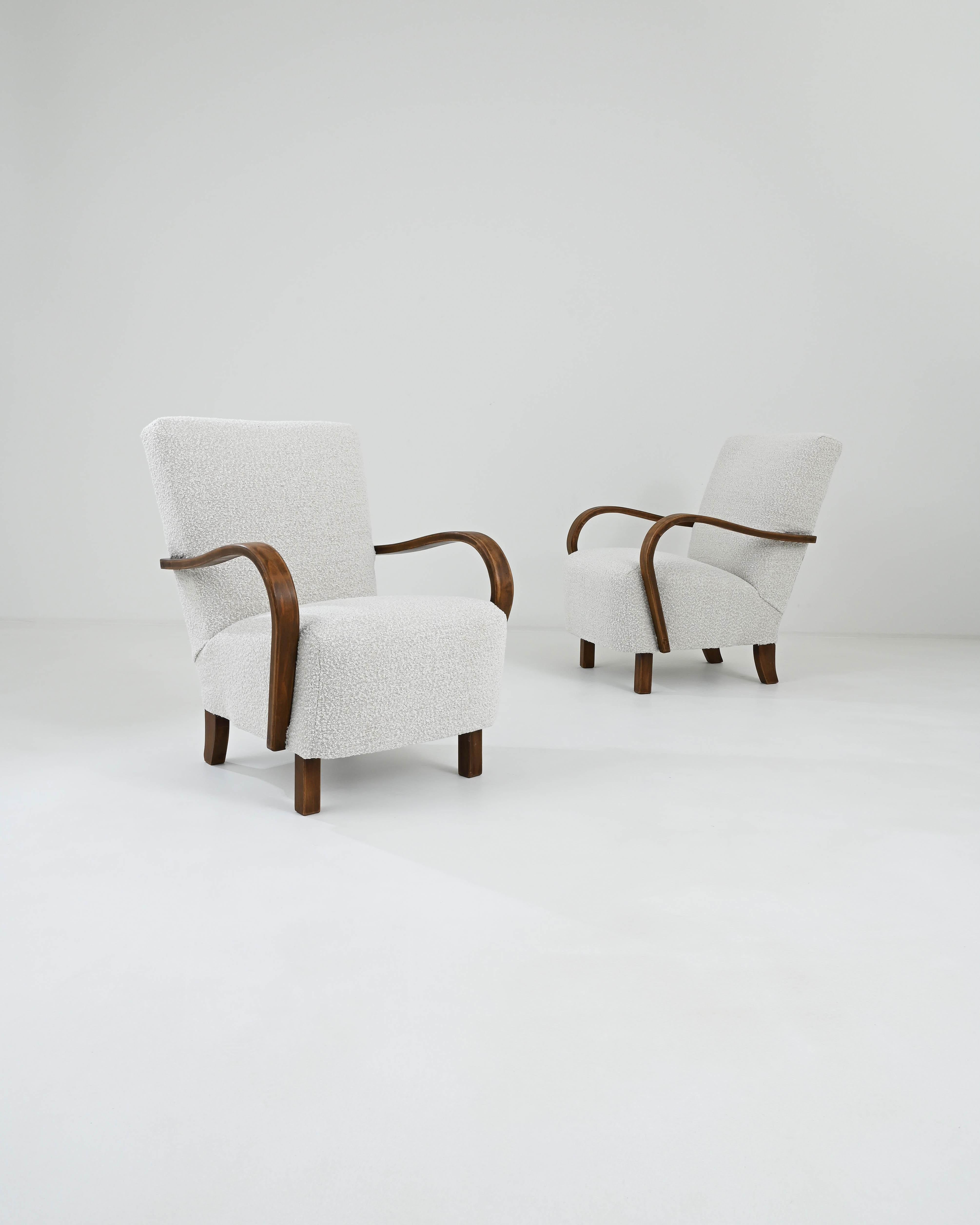 The sensuous curvature of bentwood stands as one of the defining characteristics of J. Halabala's pioneering designs. Crafted in Czechia during the 1930s, this pair of armchairs showcases undulating armrests and splayed back legs, imparting a sense