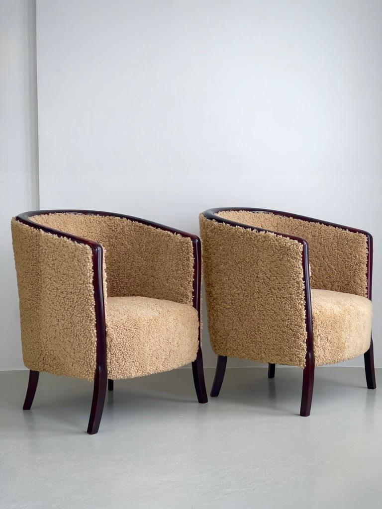 Un distinguido par de sillones Art Decó daneses de los años 30, ejemplares de la escultural ebanistería y la refinada sensibilidad material de la época. Retapizadas por nuestros profesionales en una piel de cordero marrón claro de primera calidad,