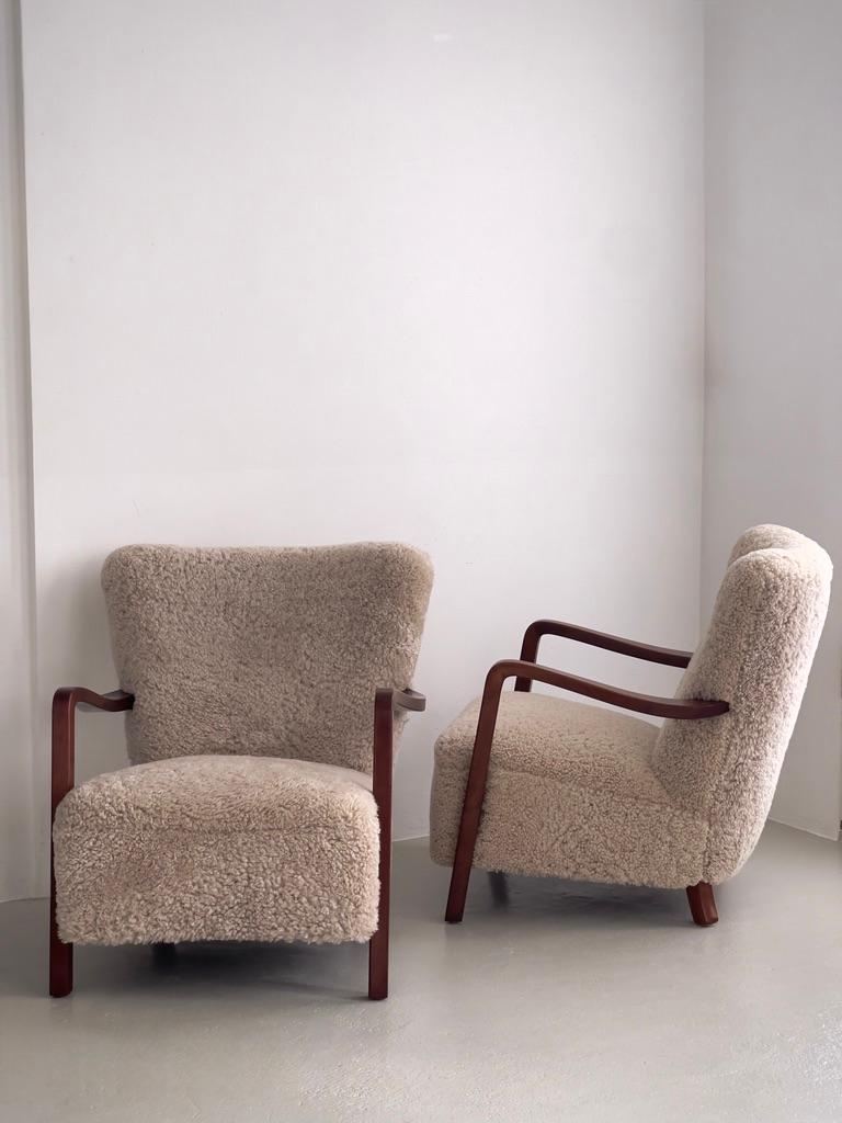 Milieu du XXe siècle Paire de chaises longues danoises des années 1930 en hêtre teinté, retapissées en shearling. en vente