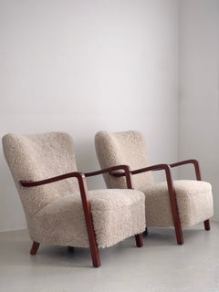 Pair of 1930s danish lounge chairs in stained beech, reupholstered in shearling