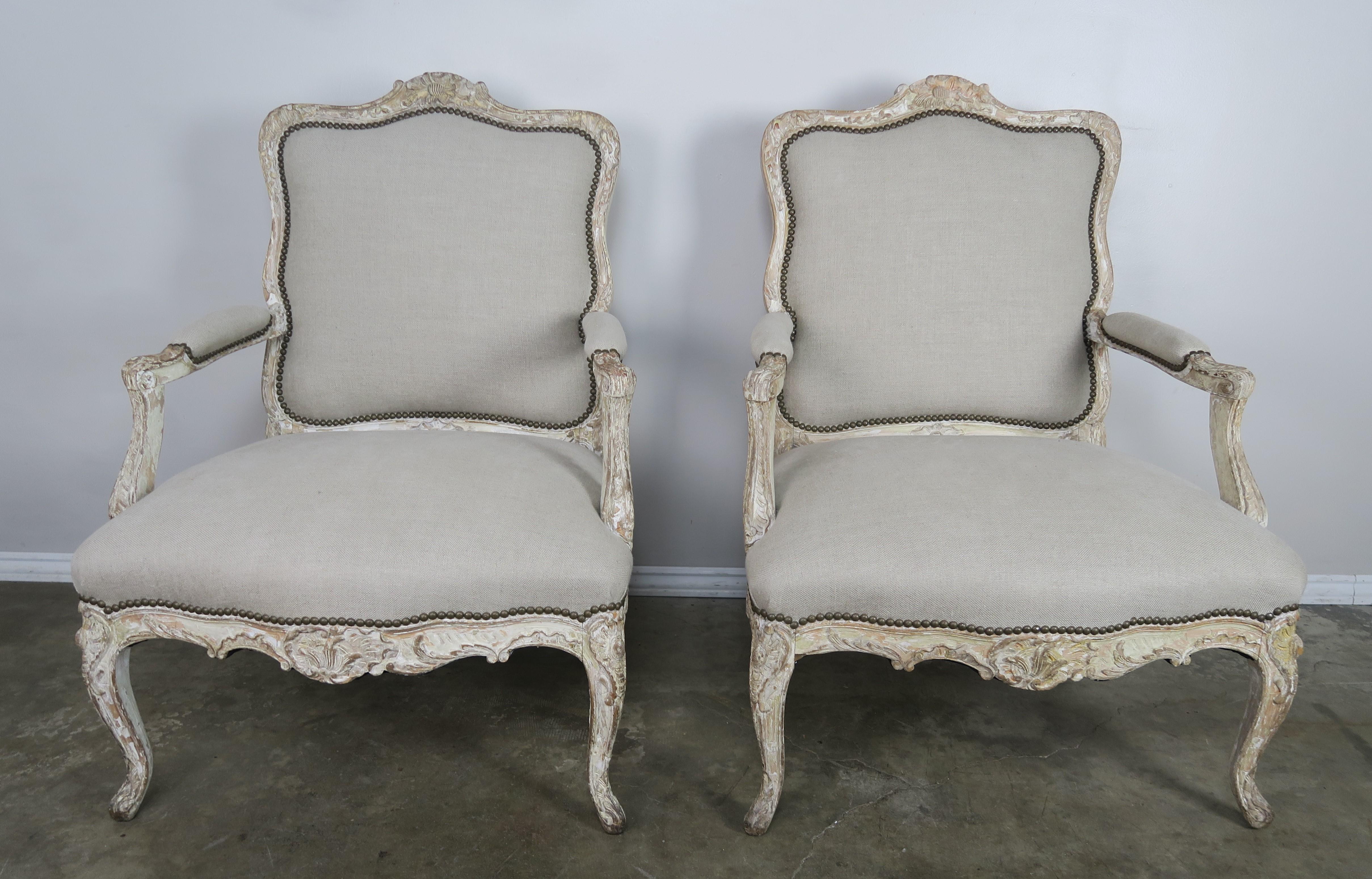 Pair of French carved wood Fauteils in a beautiful worn painted finish. The armchairs are newly upholstered in a washed Belgium linen and finished with antique brass nailhead trim detail.
Seat height 18