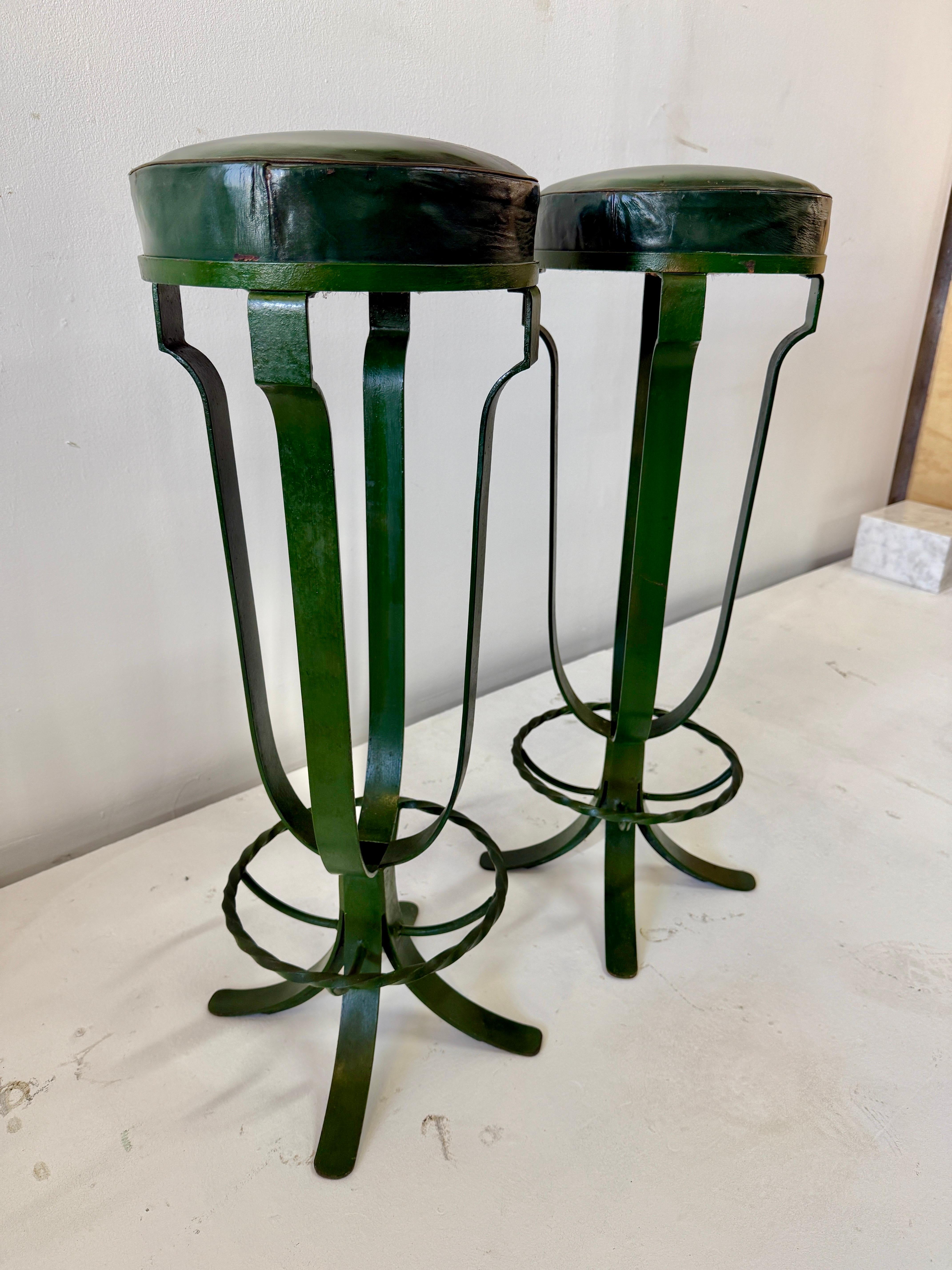 Elegantes taburetes de bar en el estado en que se encontraron, con hierro pintado en verde oscuro y asientos tapizados en cuero verde (originales de la época).  Recuerdan maravillosamente a las piezas de la época Royere.  Están increíblemente bien
