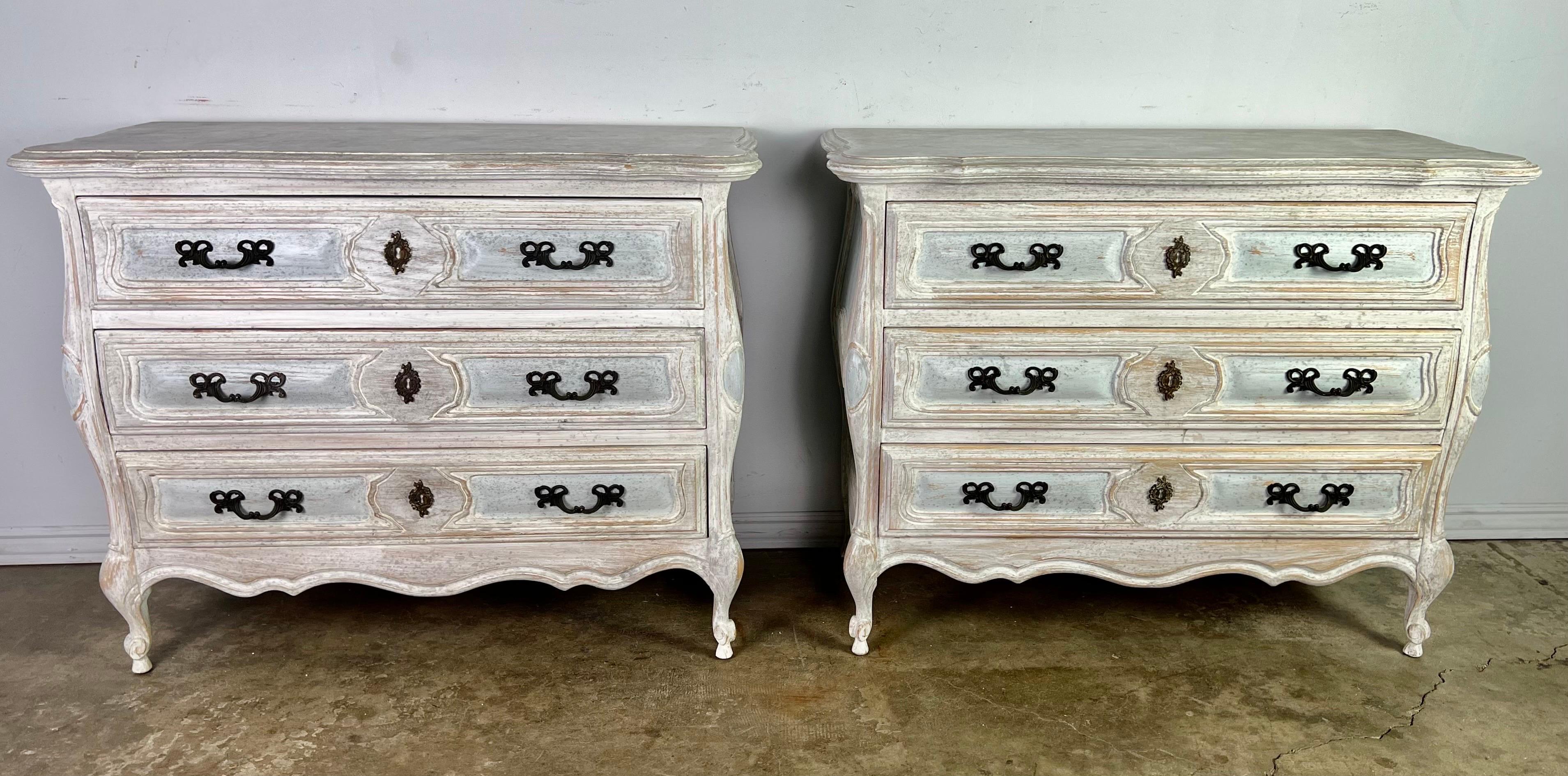 Pair of 1930's French Louis XV style commodes. The commodes are hand painted in soft hues of gray, blue and cream. They are a great addition to any bedroom. The chests stand on four cabriole legs that ends in rams head feet. Graceful scalloped apron