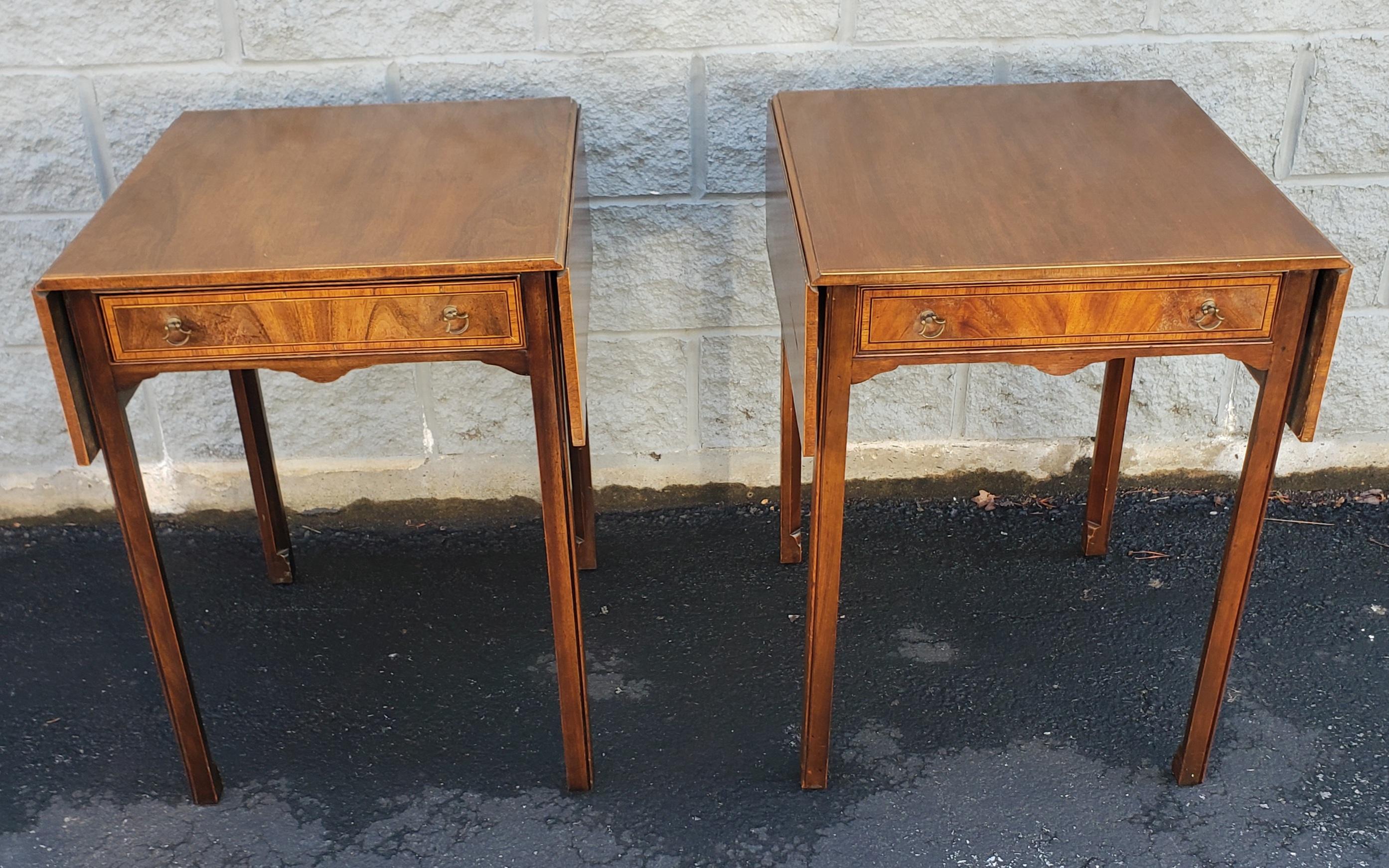 A patinated pair of 1930s George III cross-banded mahogany inlay pembroke tables measures 20.5