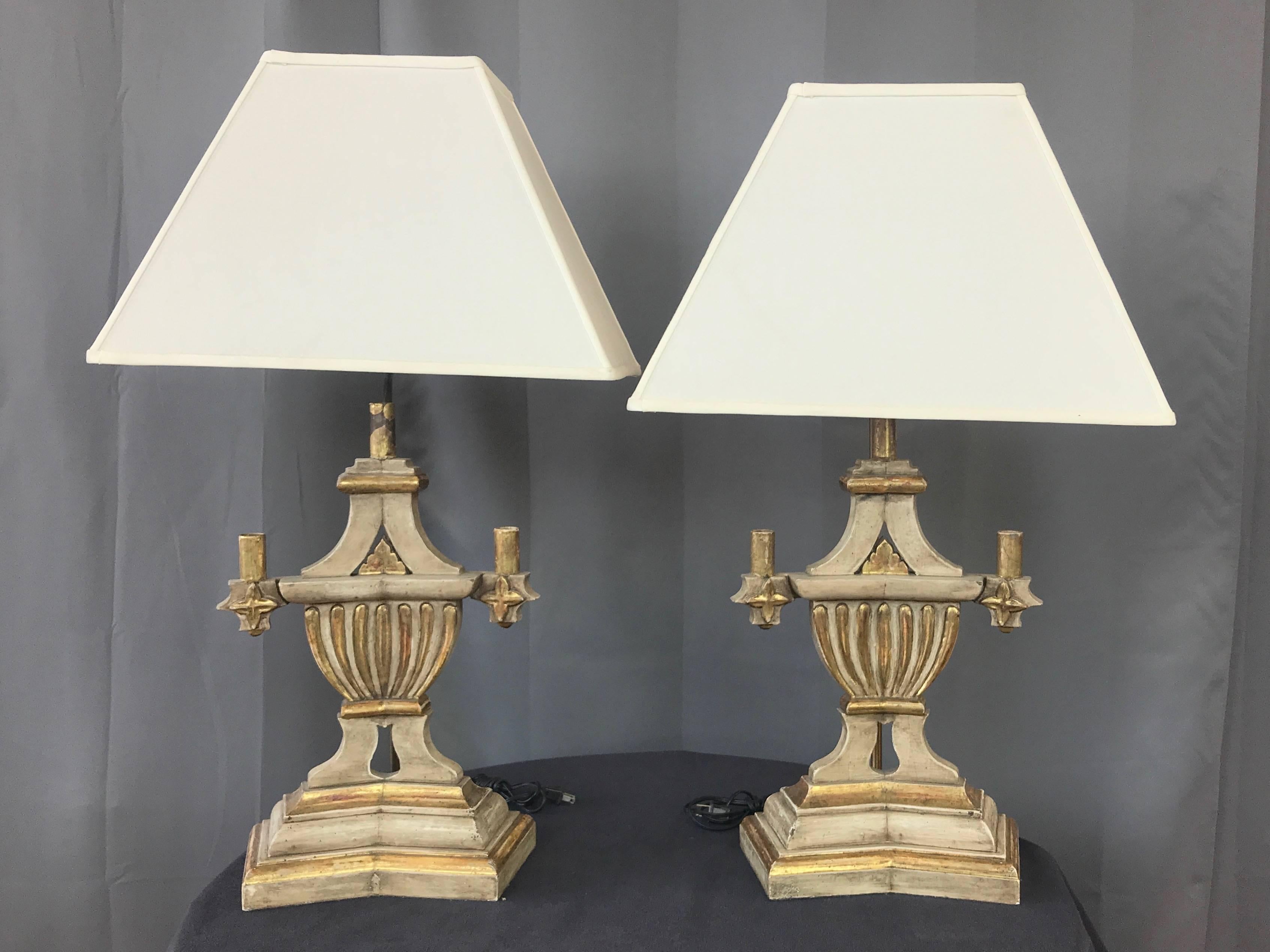A pair of 1930s Italian neoclassical-style parcel-gilt plaster and wood candleholder table lamps.

Stately architectural form of stylized urn body with a trio of candleholders on a stepped and angled base. Plaster over hand-carved wood, with a
