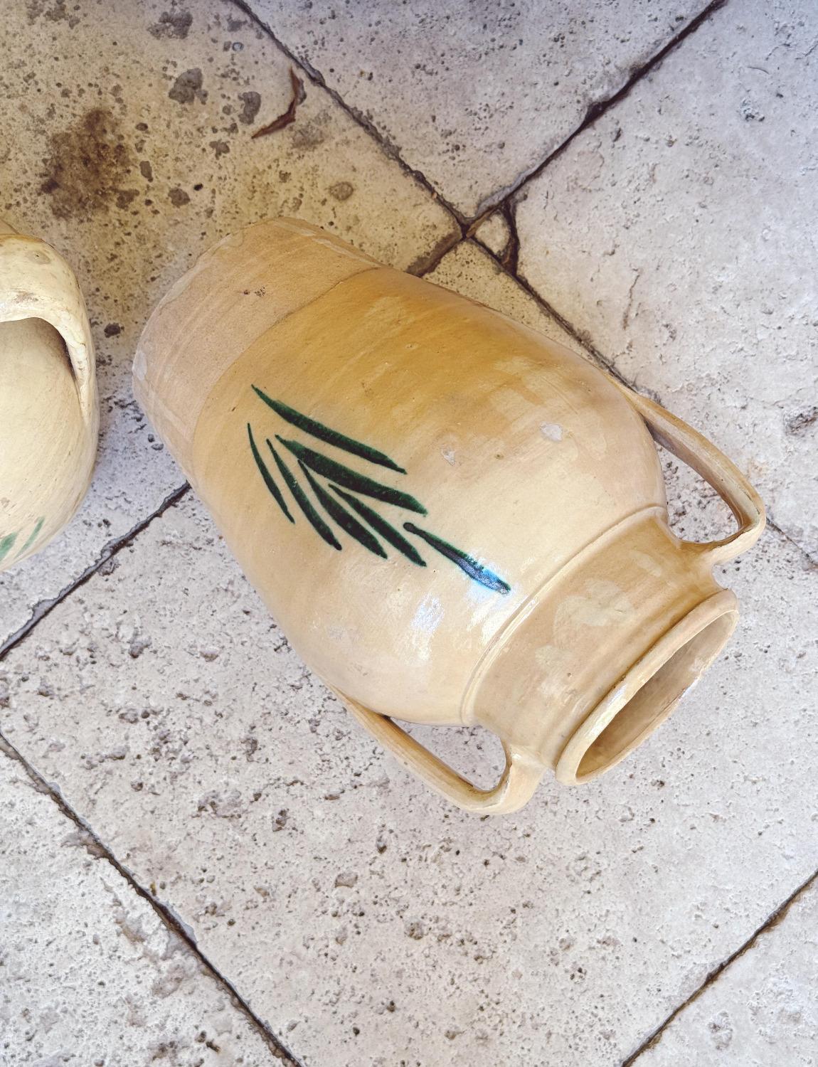 Une paire de pots rustiques avec des décorations en forme d'arbre de vie sur le devant. Ces pots ont été fabriqués au début des années 1900 et servaient à conserver l'eau et le vin. L'arbre de vie symbolise la bonne fortune et la longévité. Ils