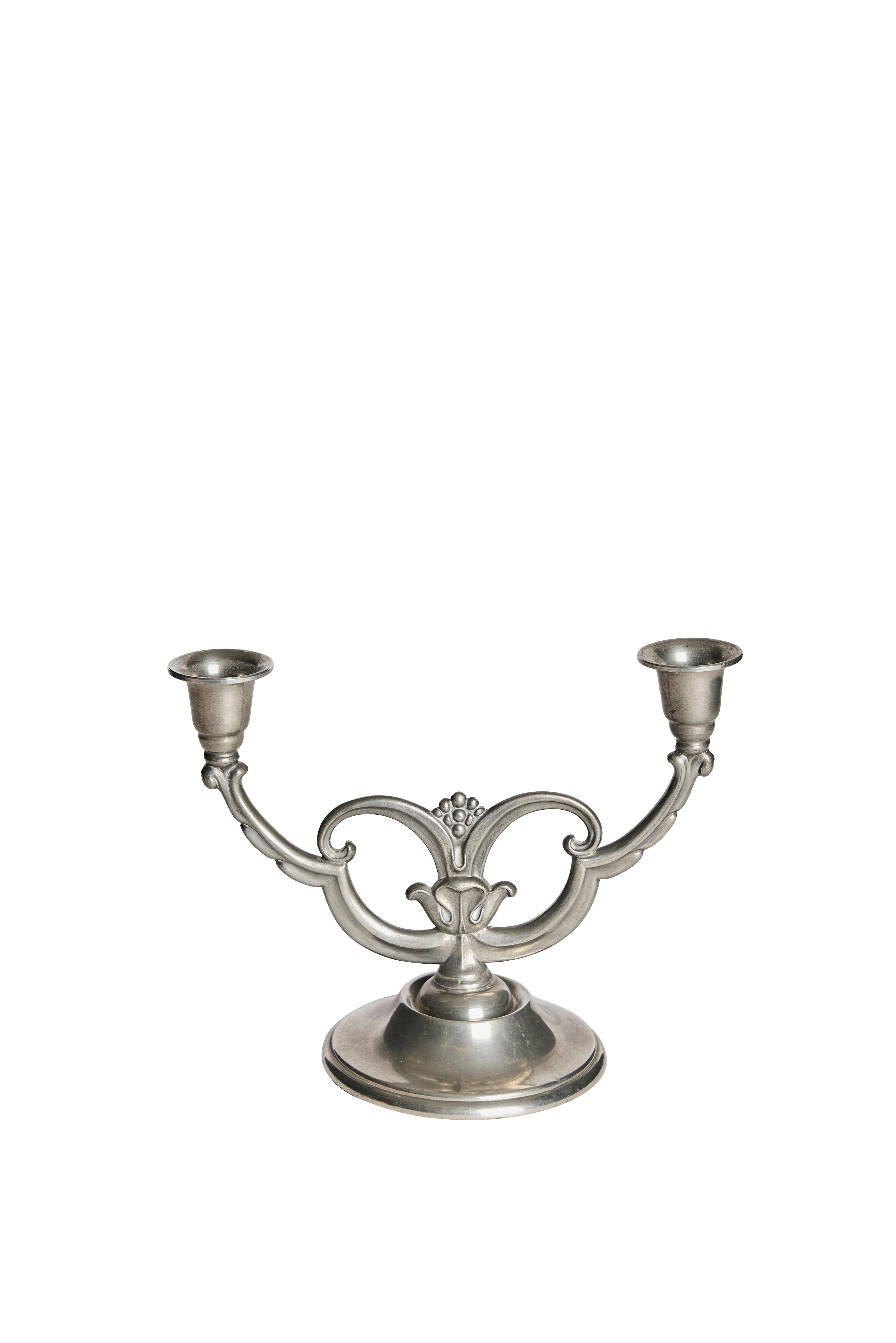 Elegant pair of two-arm pewter candelabra designed by Johan L. Hultman (JLH) in Svenskt Tenn in Sweden during the 1930s. These sculptural candleholders reflect the graceful Scandinavian interpretation of the Art Deco style, with stylized floral