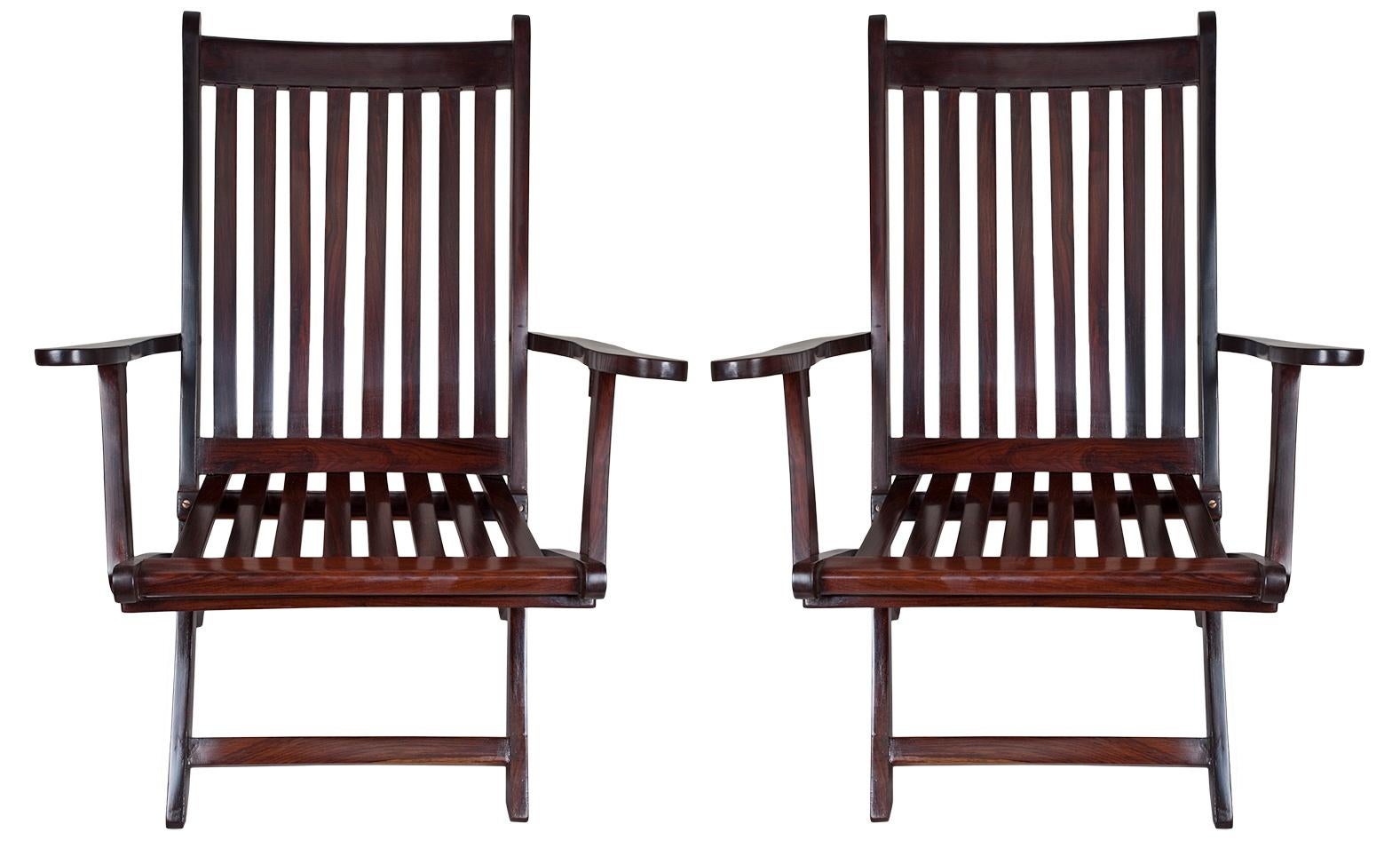 Pair of folding rosewood steamer chairs from the 1930s. Used by passengers on the deck during sea voyages. British. Refinished slatted rosewood and slightly reclined back for comfort.  Use on your deck, patio, veranda or inside as a side chair.