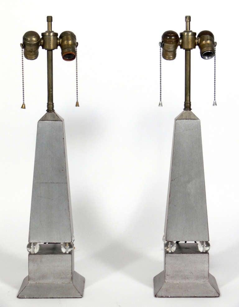 Pair of silver leaf Obelisk lamps, American, circa 1930s. They exhibit wonderful patina and wear to the silver leafing, beautifully exposing some of the Chinese Red color underlayer or bole.