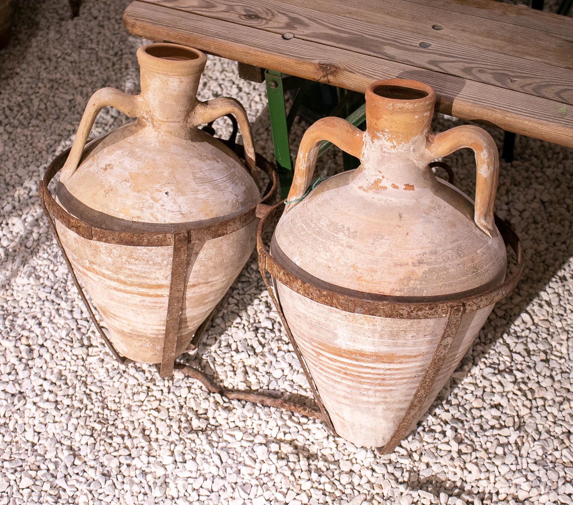 Pair of 1930s Spanish terracotta vases with iron basket to be carried by mules or donkeys.