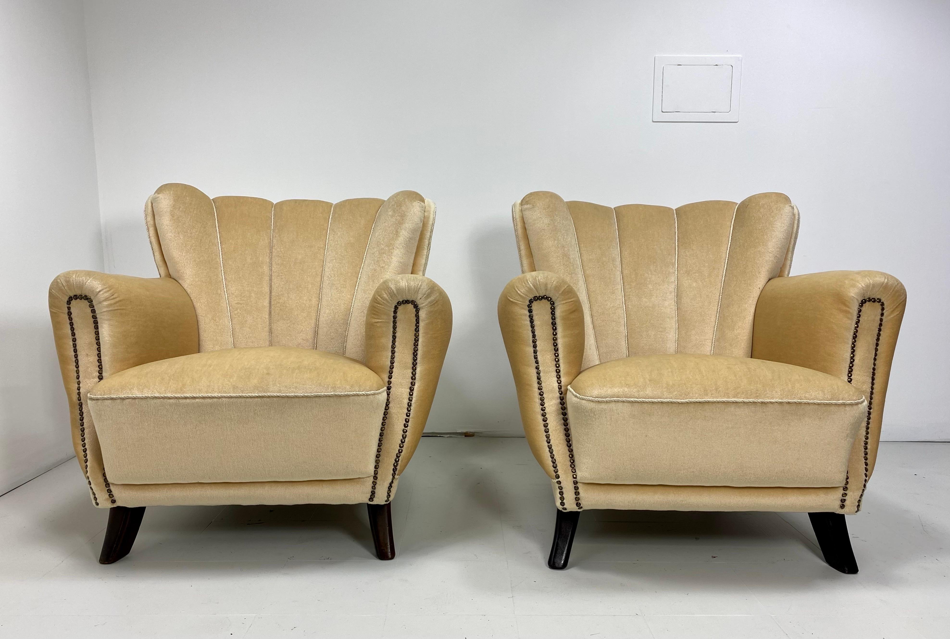 Pair of 1930s Swedish lounge chairs. Stained beech legs. Vintage velvet upholstery. Sculpted upholstery along the profile of the chairs. Nail head detailing.