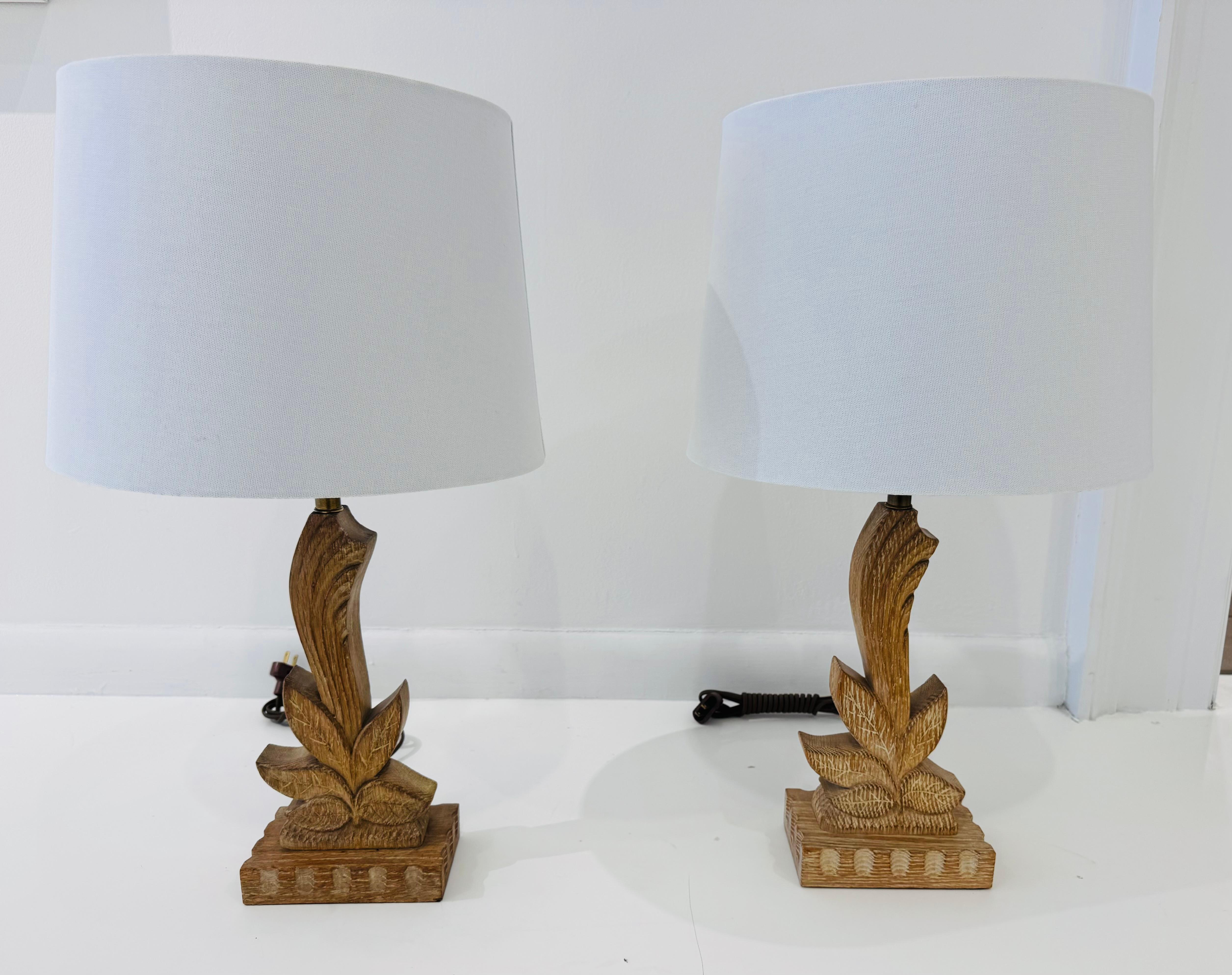 Magnifique paire de lampes de table en bois sculpté de style Art Déco américain avec doubles douilles en laiton vieilli et cordons en soie. Recâblé. 