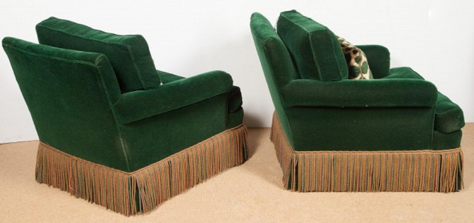 Paire de fauteuils club Art Déco en velours vert des années 1940.  Les chaises ont des jupes à franges et le tissu en velours d'origine. Les oreillers ne sont pas originaux, mais bien faits.  Il y a une paire d'ottomans assortis listés et vendus