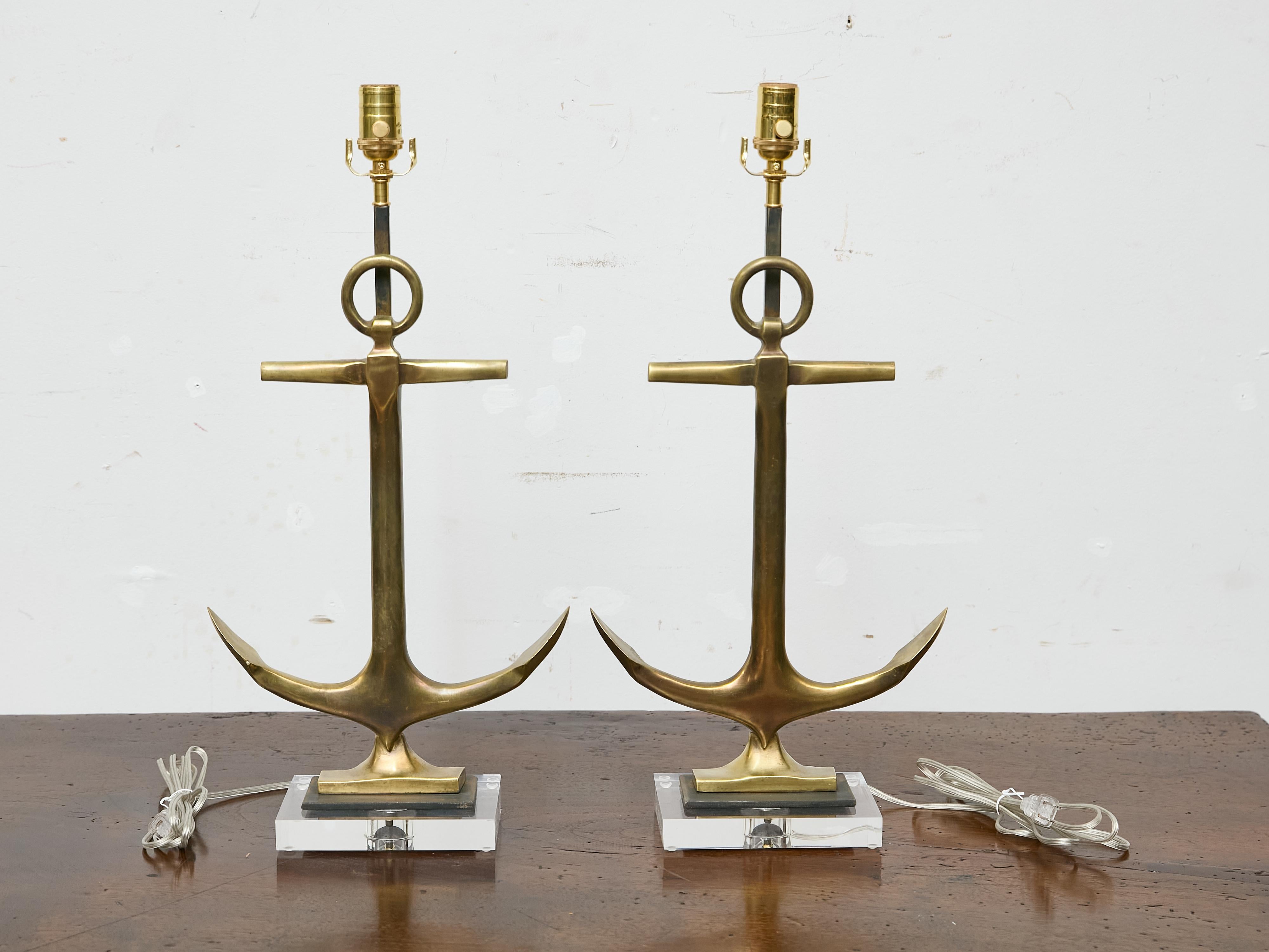 A pair of 1940s American bronze anchors repurposed as modern table lamps, professionally wired for use in the USA and mounted on thick lucite bases. The solid cast bronze retains a mellow patina, its sharp contours and smooth curves made even more