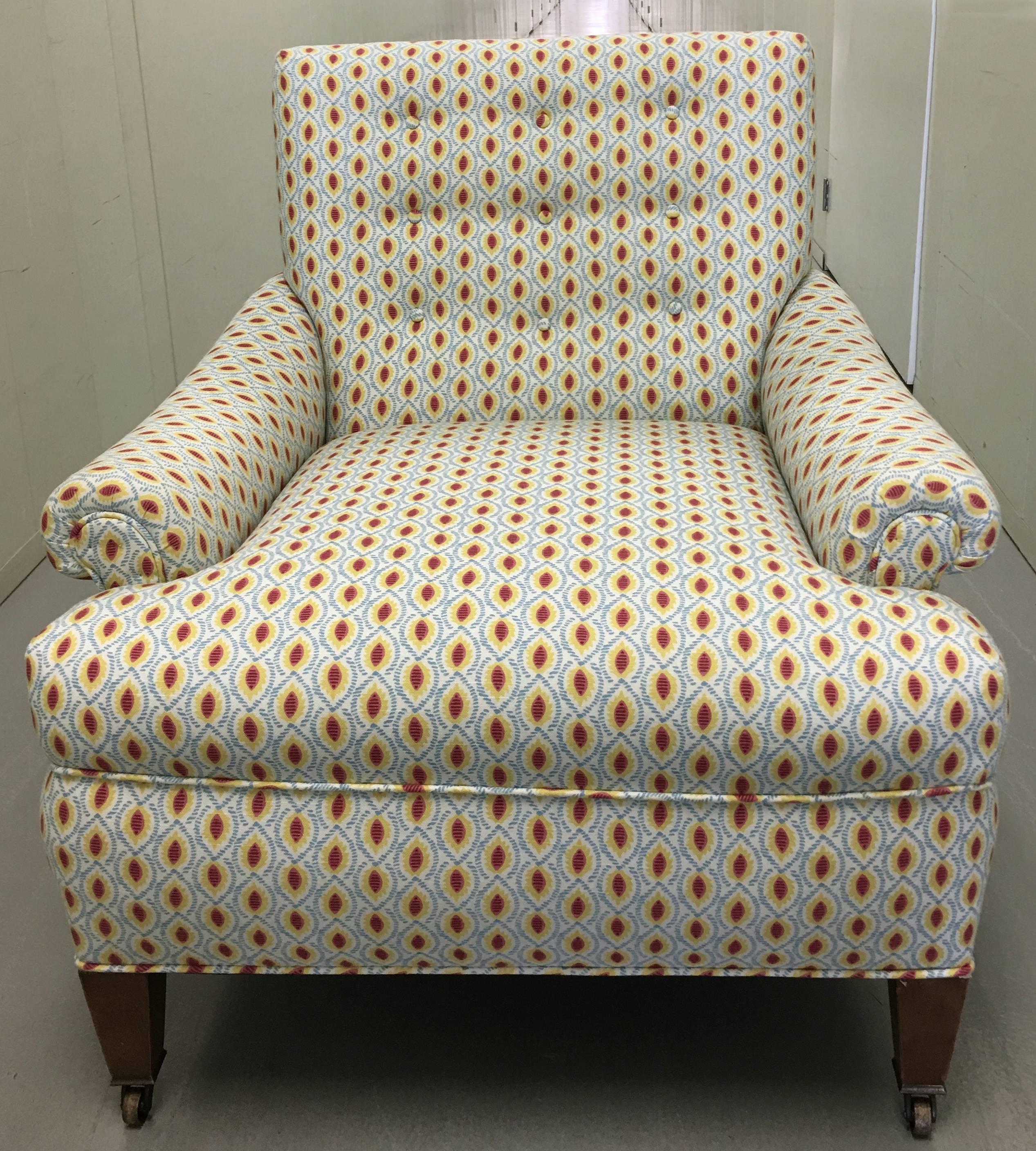 Pair of comfortable 1940s club chairs. Recently upholstered in a cotton block print. Original wood legs and brass castors. Seat is 18