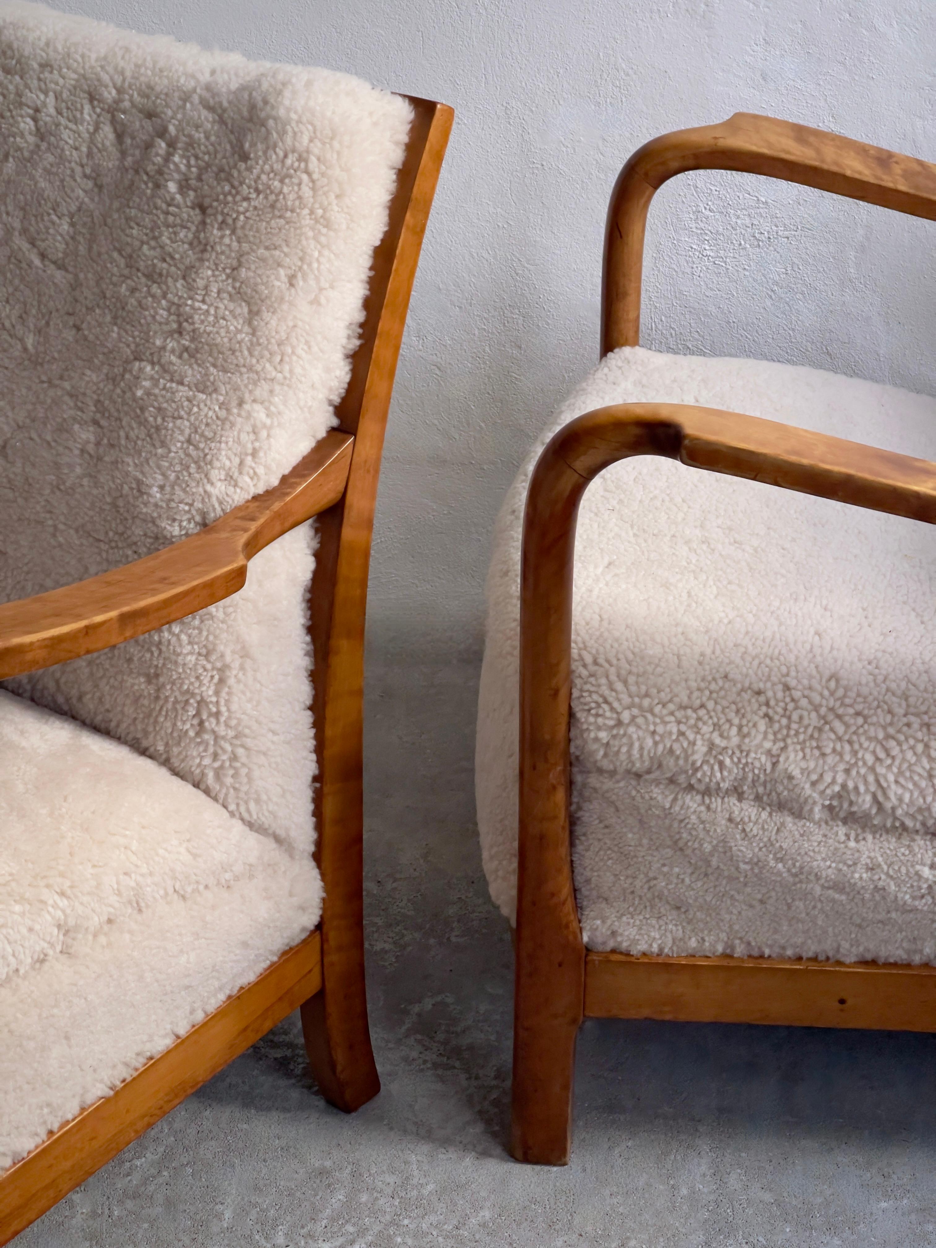 Mid-20th Century 1940s pair of danish lounge chairs in solid flamed birch and premium sheepskin.