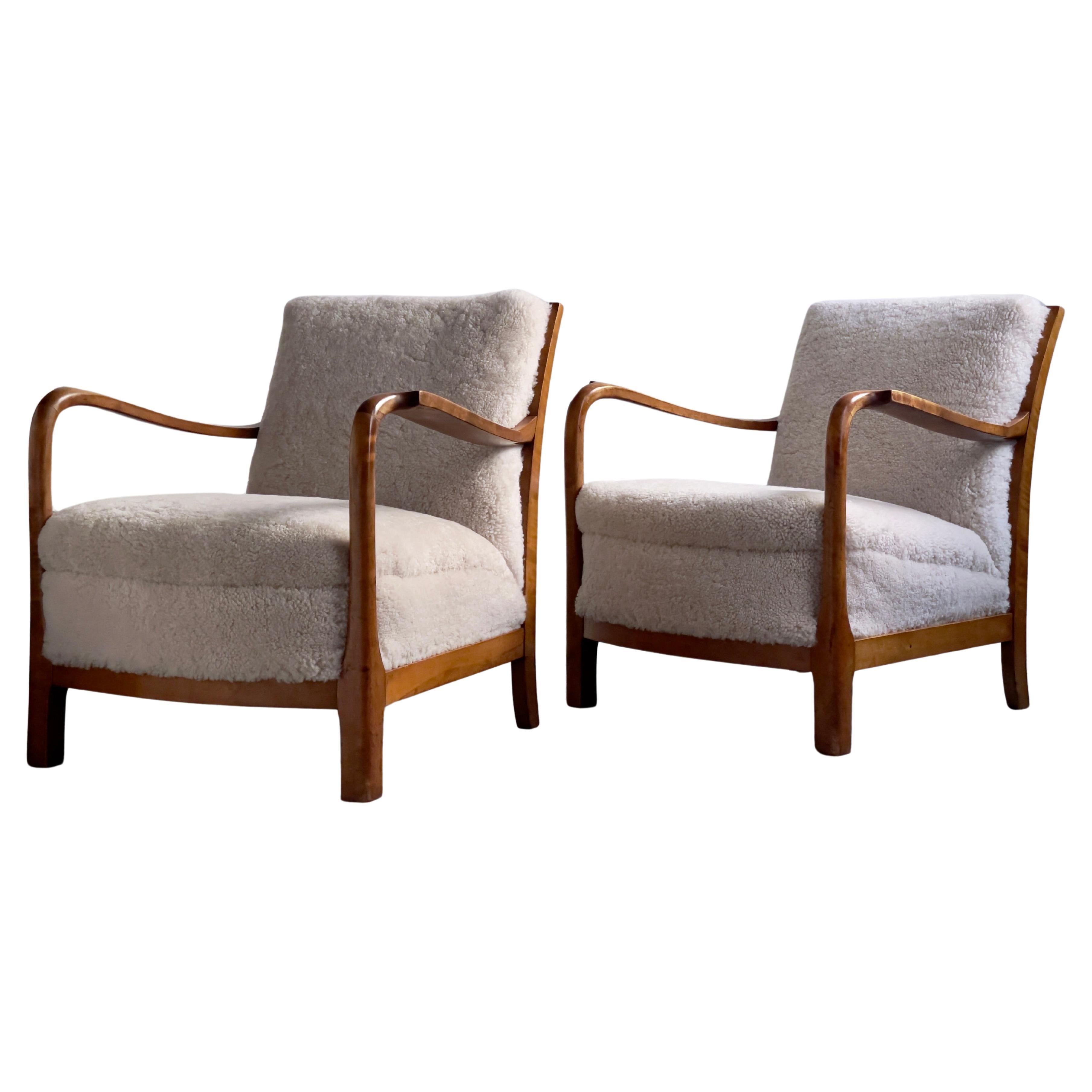 1940s pair of danish lounge chairs in solid flamed birch and premium sheepskin.