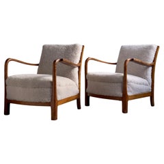 1940s pair of danish lounge chairs in solid flamed birch and premium sheepskin.