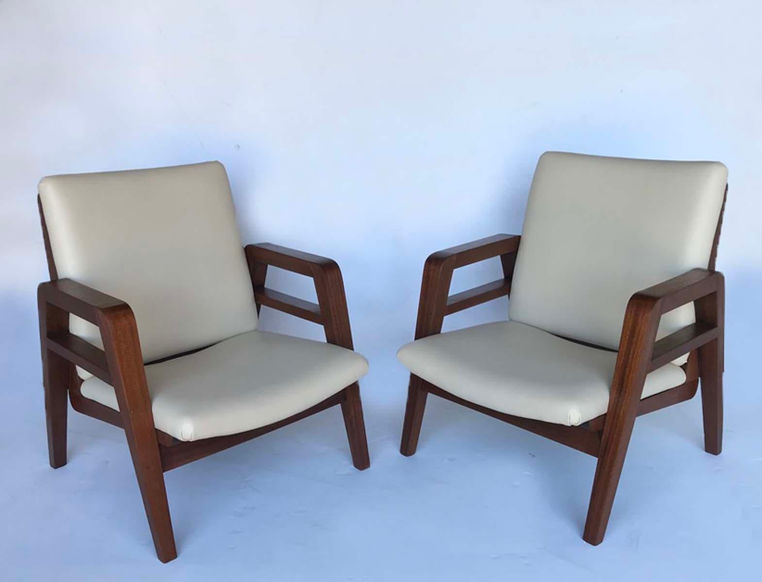 Handsome pair of French 1940s mahogany armchairs. Newly upholstered in cream color embossed leather.
Clean lines, great profile. The seat height is 13 inches and the seat depth is 18.5 inches.
These are both in very, very good condition with new