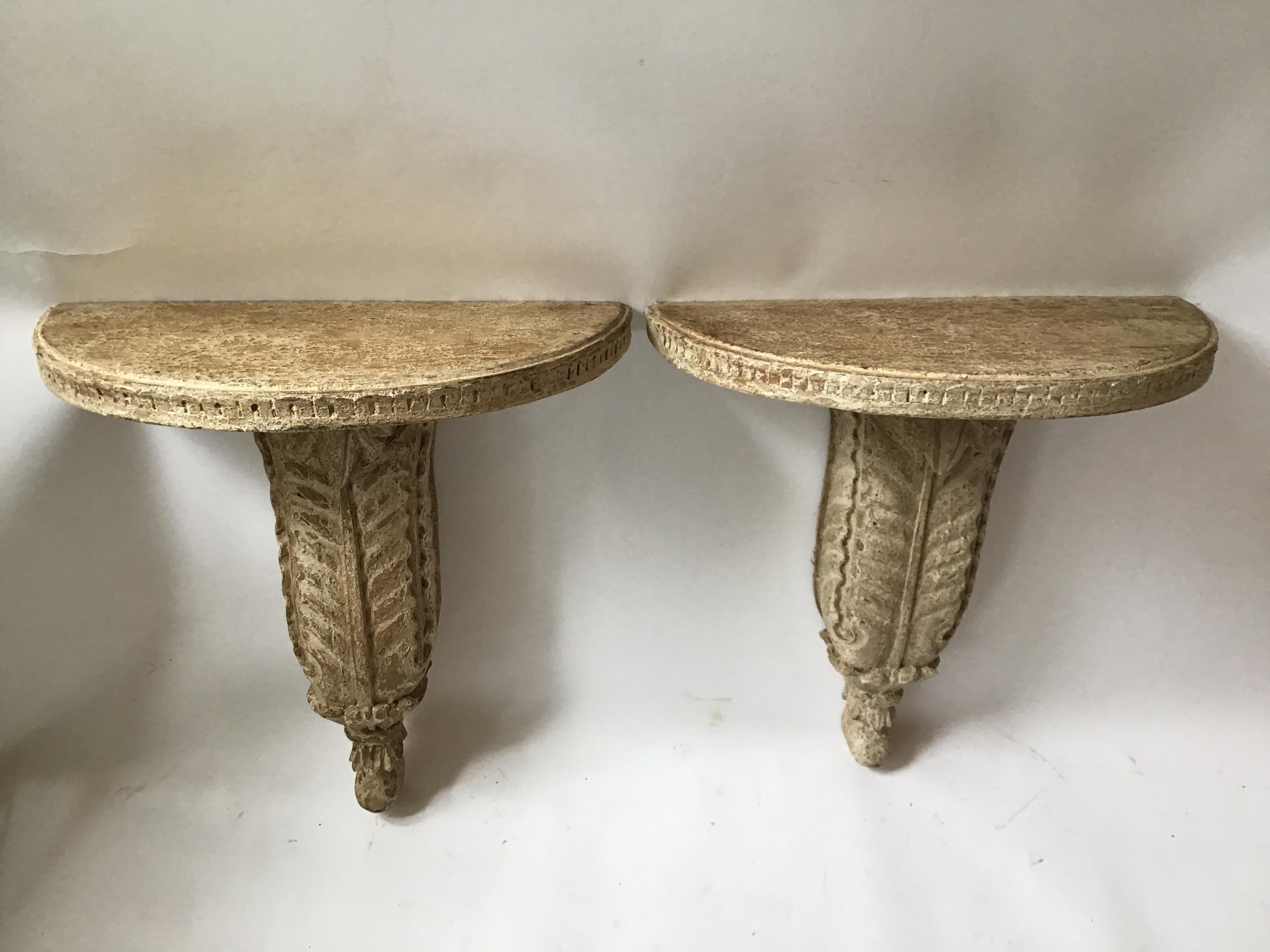 Pair of 1940s Hollywood Regency carved wood wall consoles. These consoles were found in a barn in Armonk, NY. Being in the barn for many years created this finish on the consoles that you see.