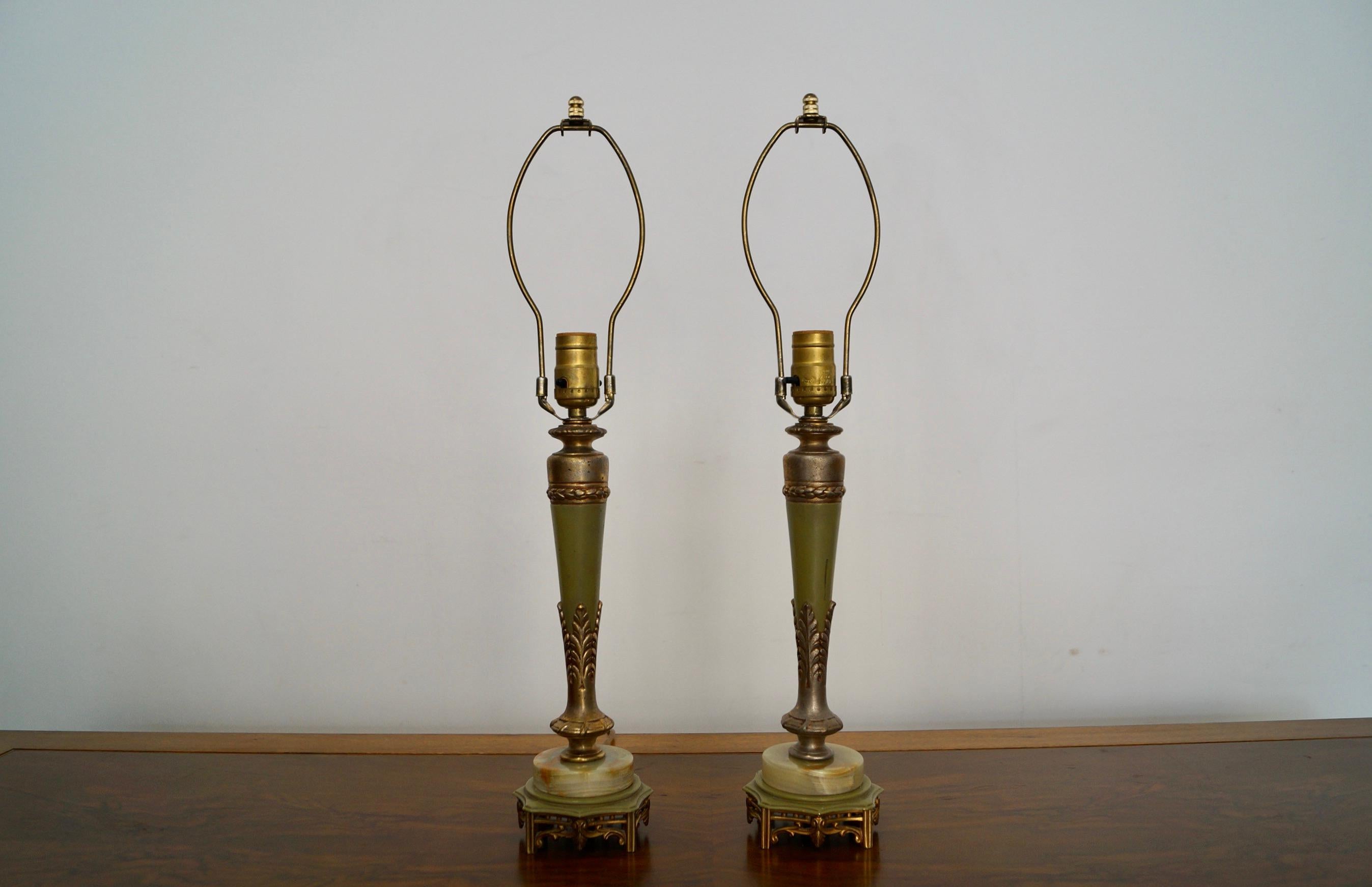 Pair of vintage 1940’s Hollywood Regency table lamps for sale. Manufactured by Rembrandt, and are in excellent condition. They have a brass, metal, and marble marble base with a metal and brass stem. They are a beautiful olive green tone with