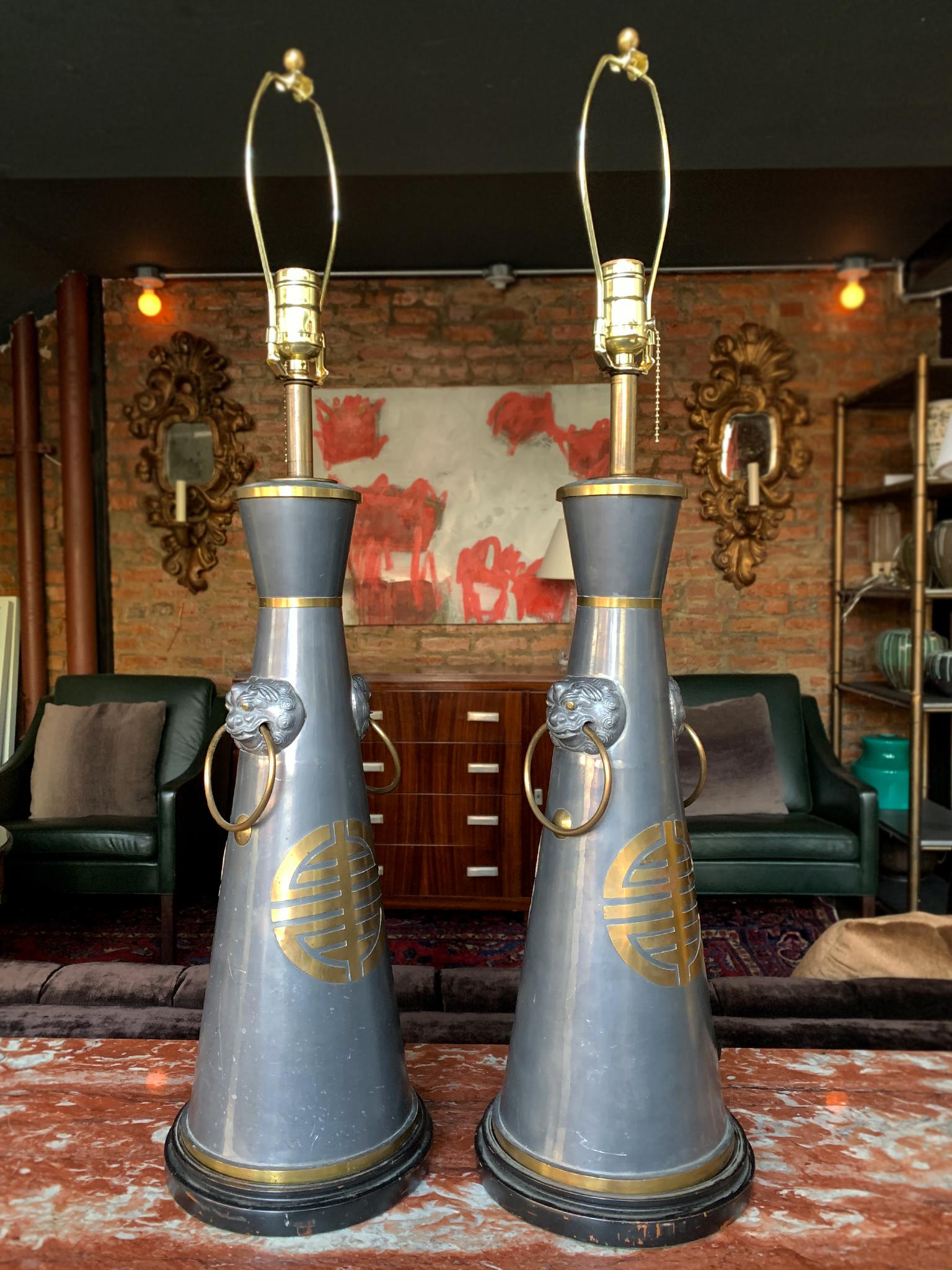 These 1940s table lamps remind us of the eclectic Hollywood Regency style of James Mont, whose various influences - from modernism to chinoiserie - converged in his furniture and lighting. The lamps have a pewter body with mounted brass trims and