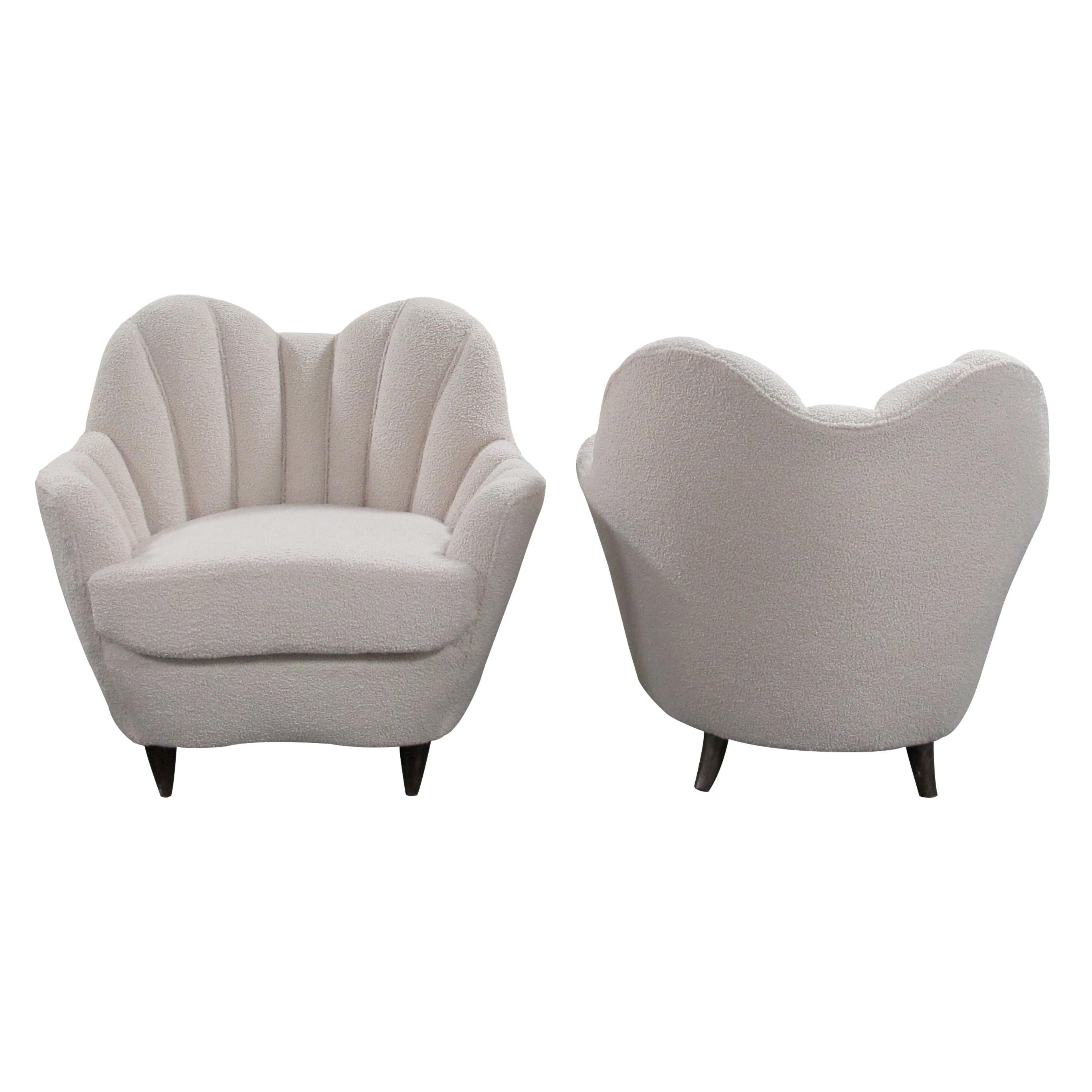 A pair of 1940s scallop shaped armchairs which are in the style of the Italian designer Gio Ponti. These elegant, and very comfortable, Art Deco armchairs boast really beautiful and accentuated curves. Newly reupholstered in a cream-colored Bouclé