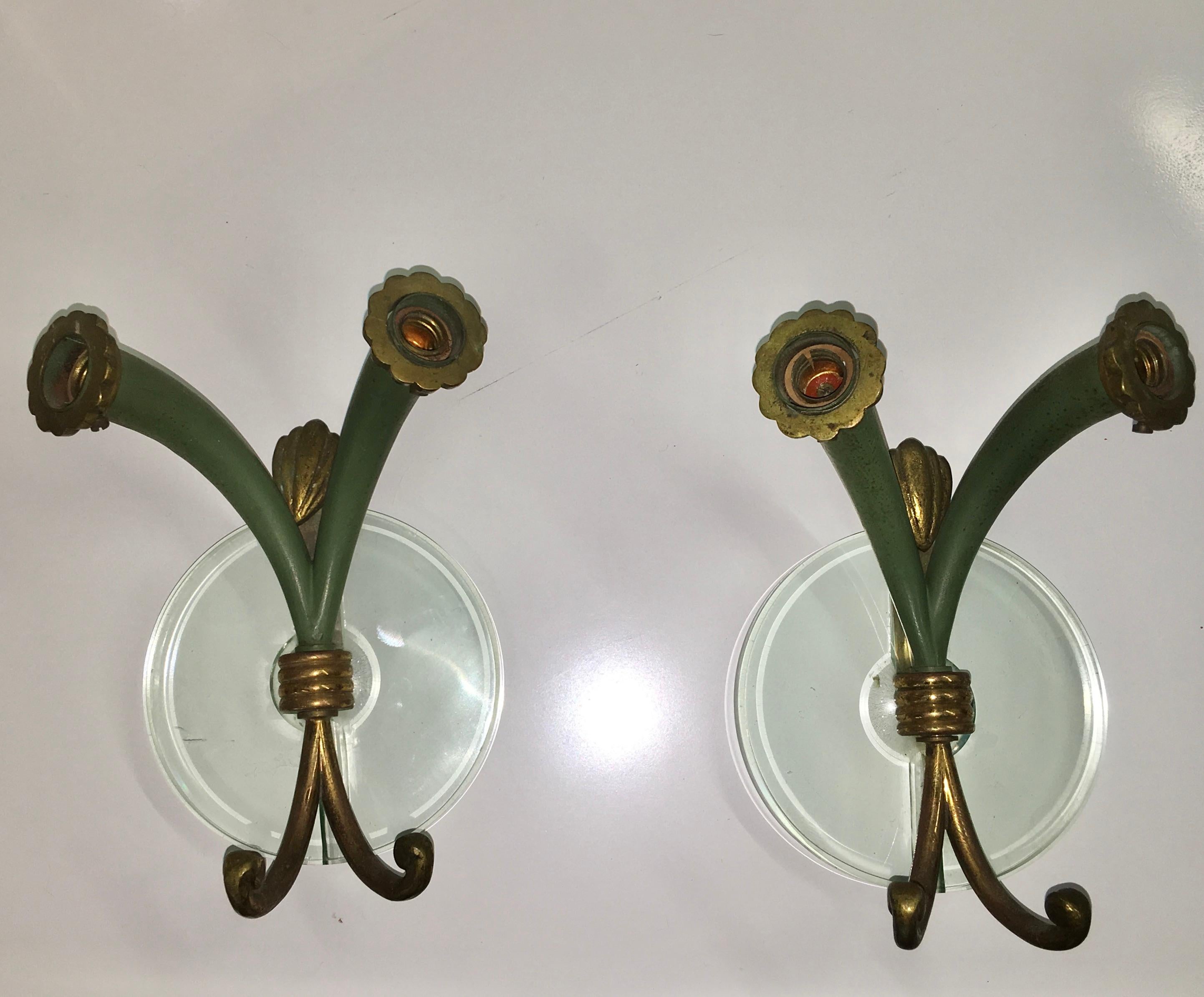 Elegant and diminutive pair of wall lights which appear also to double as coat hooks!
Tapered cast bronze cornucopia shaped trumpet cones in original green enamel with scalloped bronze collars around two candelabra size lightbulb sockets.
Mounted
