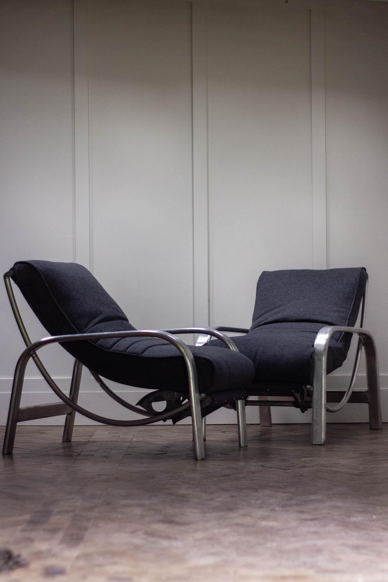 A pair of Christie Tyler 1940s reconditioned lounge chairs, with an aluminium and steel frame.

Both chairs have been fully reupholstered in grey wool fabric. 

Measures: Height 80cm
Width 64cm
Depth 93cm.