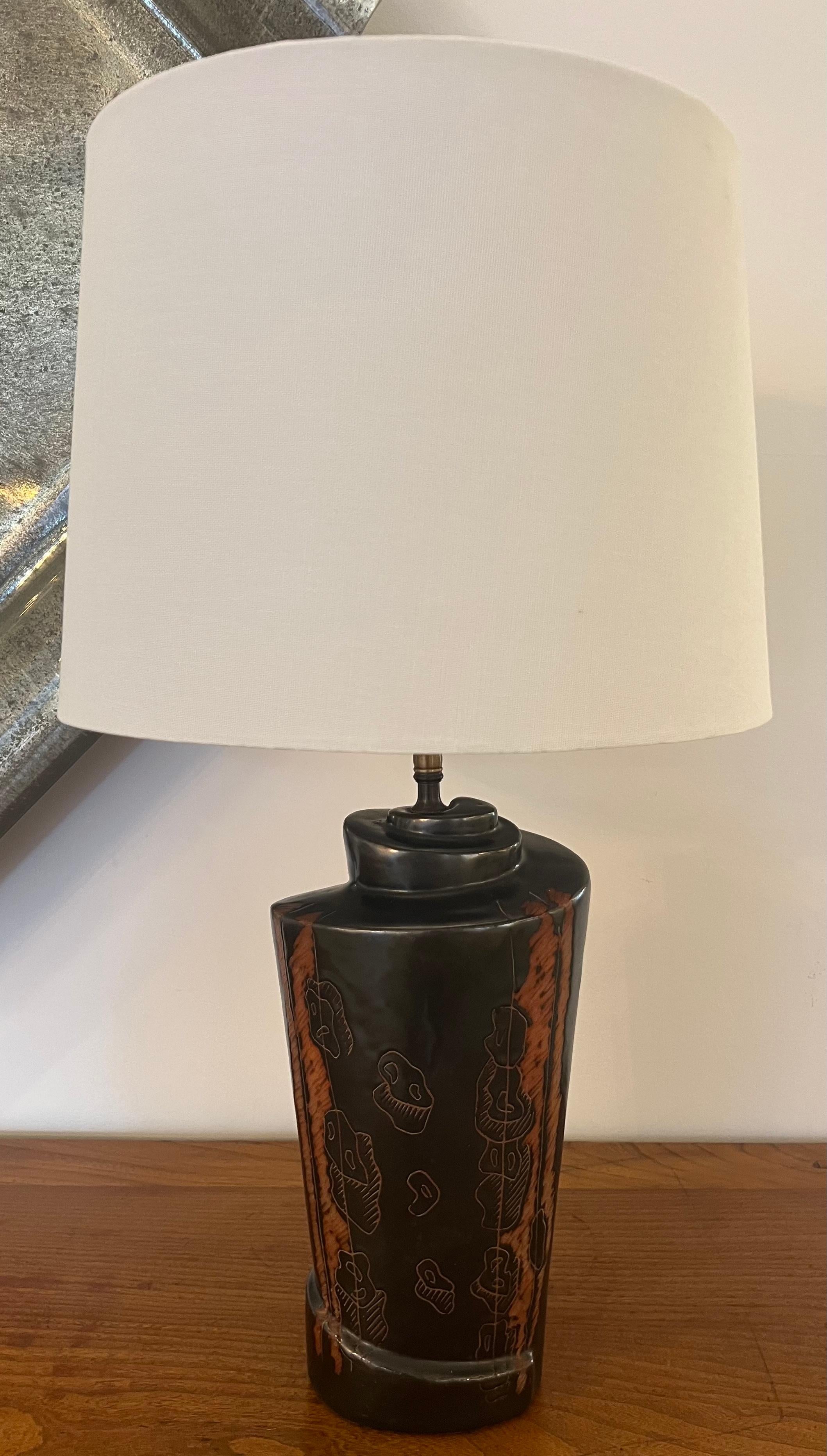 Pair of original art pottery table lamps by famed American artist, Marianna con Allesch. Signed. Rewired with aged brass double sockets and brown cloth cords. The ceramic bodies are 13” tall in colors of matte gunmetal and rust brown with incised