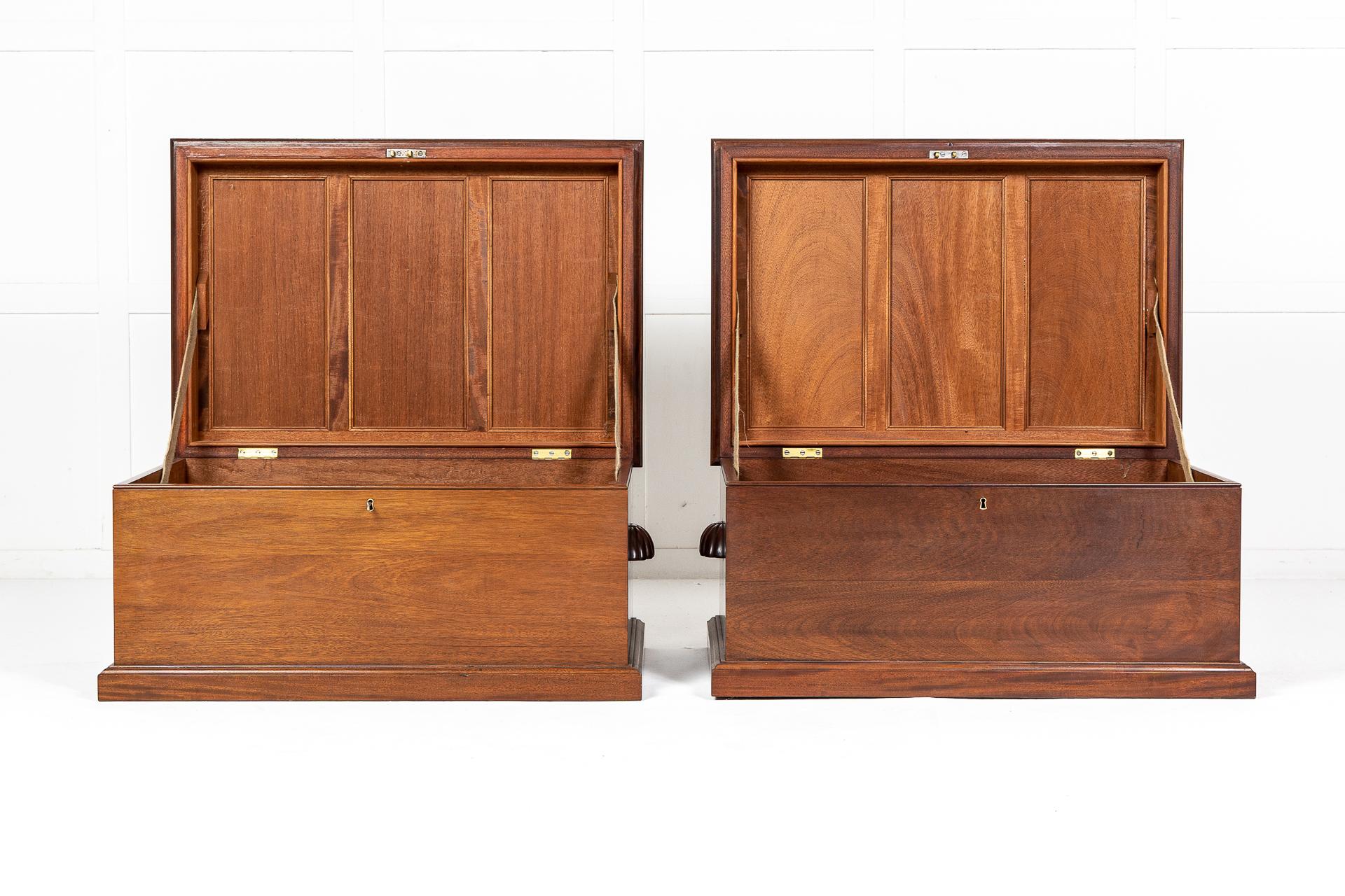 A pair of exceptional quality 1940s trunks constructed in solid mahogany. Having panelled tops with hinged lids that stay open with fabric stays. A well-presented, fine quality panelled interior offers lots of space for storage. Carved wooden, cup