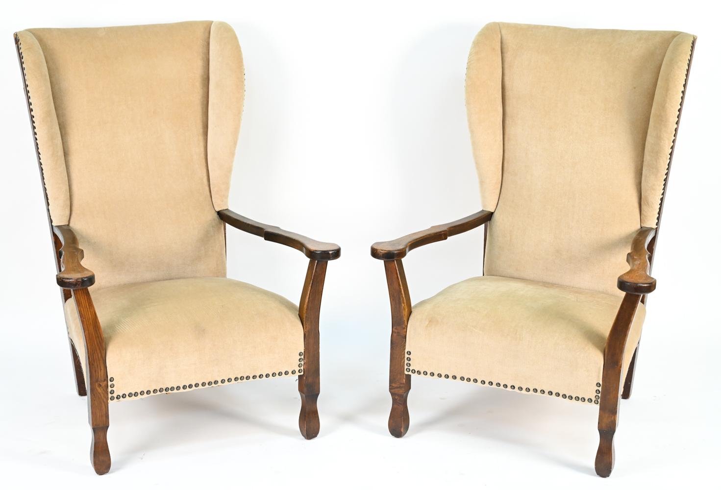 A handsome pair of 1940's highback lounge chairs with oak frames and tacked upholstery. Style of Frits Henningsen and from the Fritz Hansen era. 