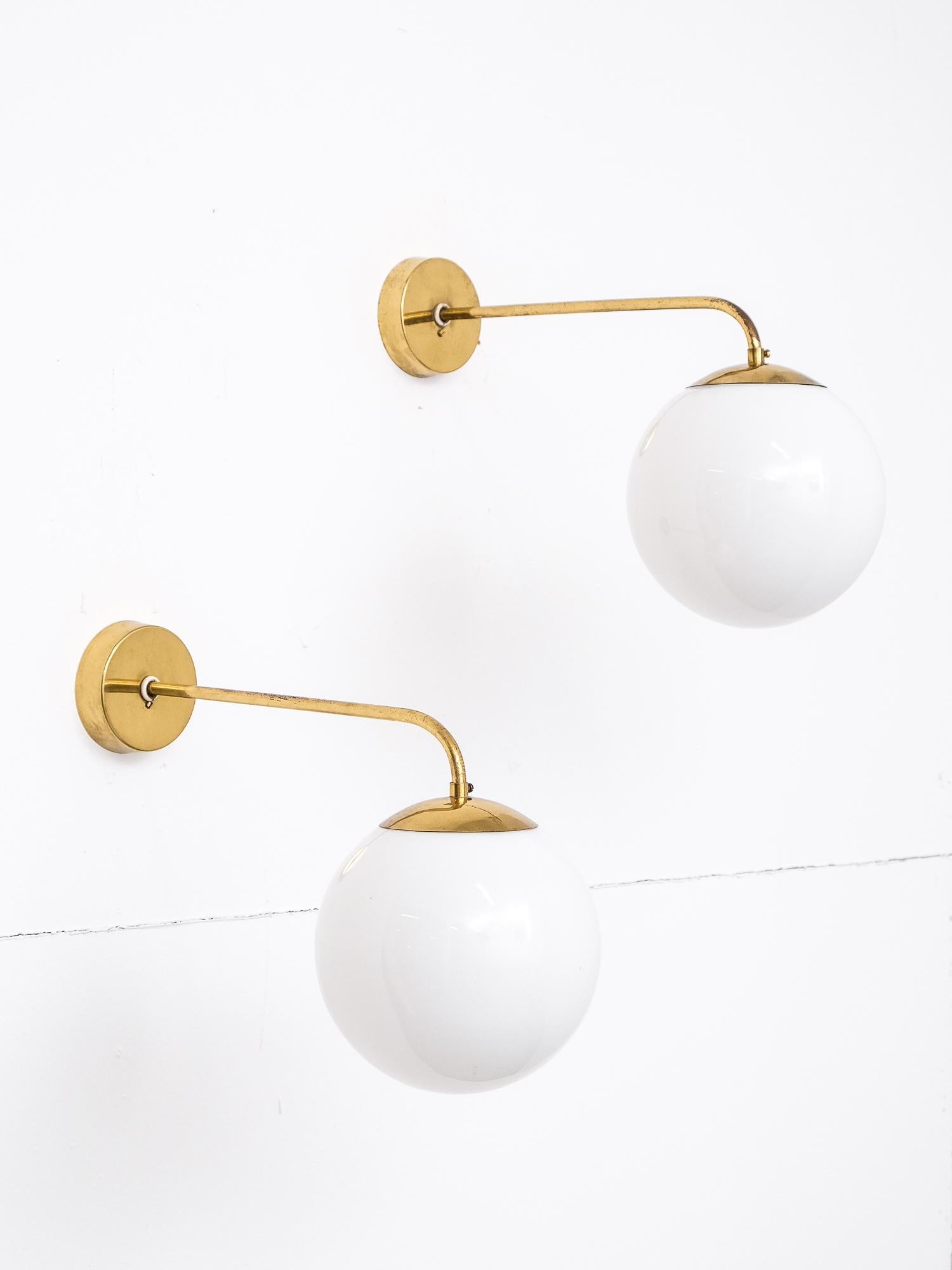 Pair of 1940s wall lamps in solid brass and white opaline glass produced by Idman in Finland.